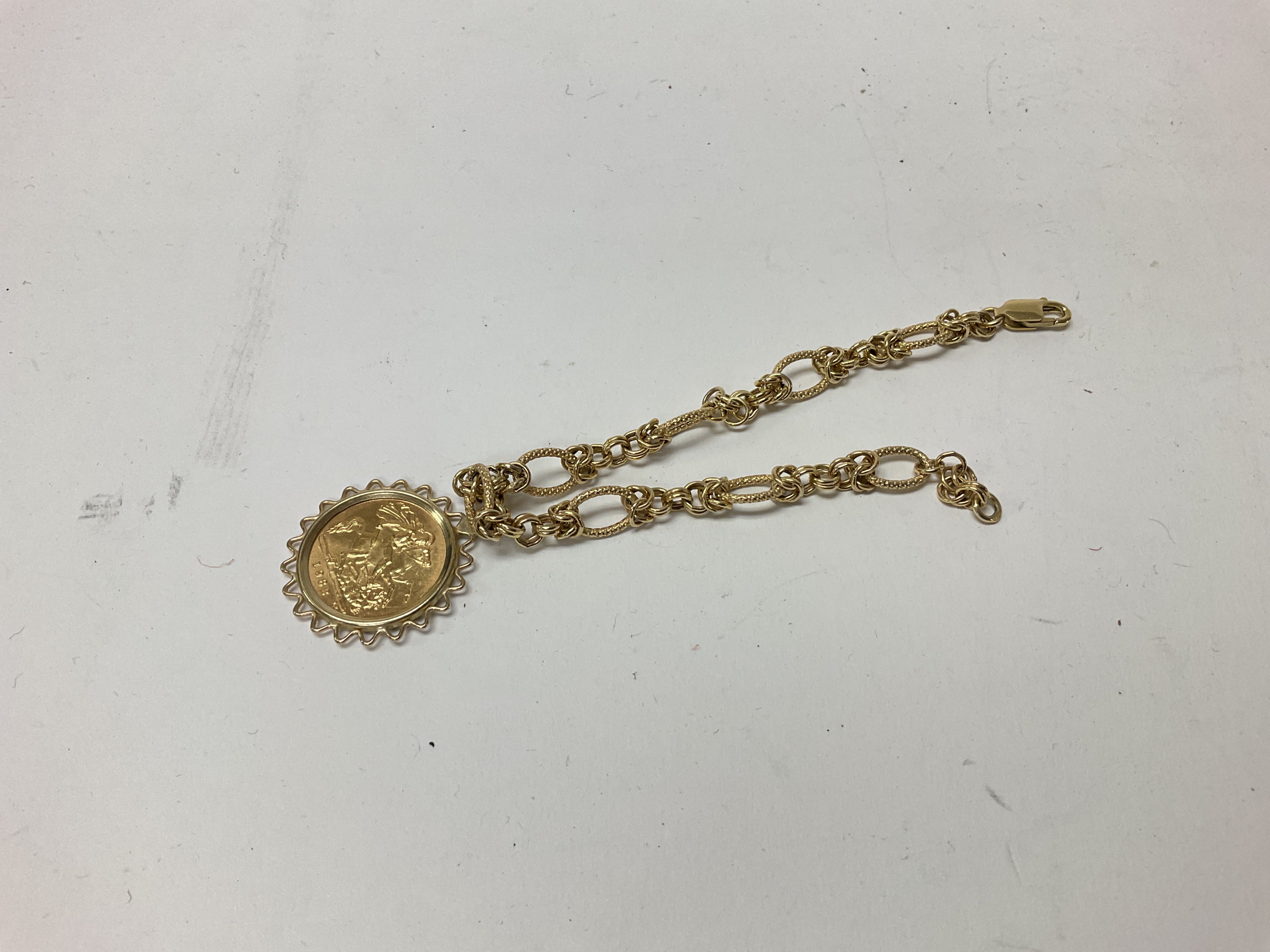 A half sovereign pendant on a 9ct gold bracelet. Approx weight 8.5 grams.