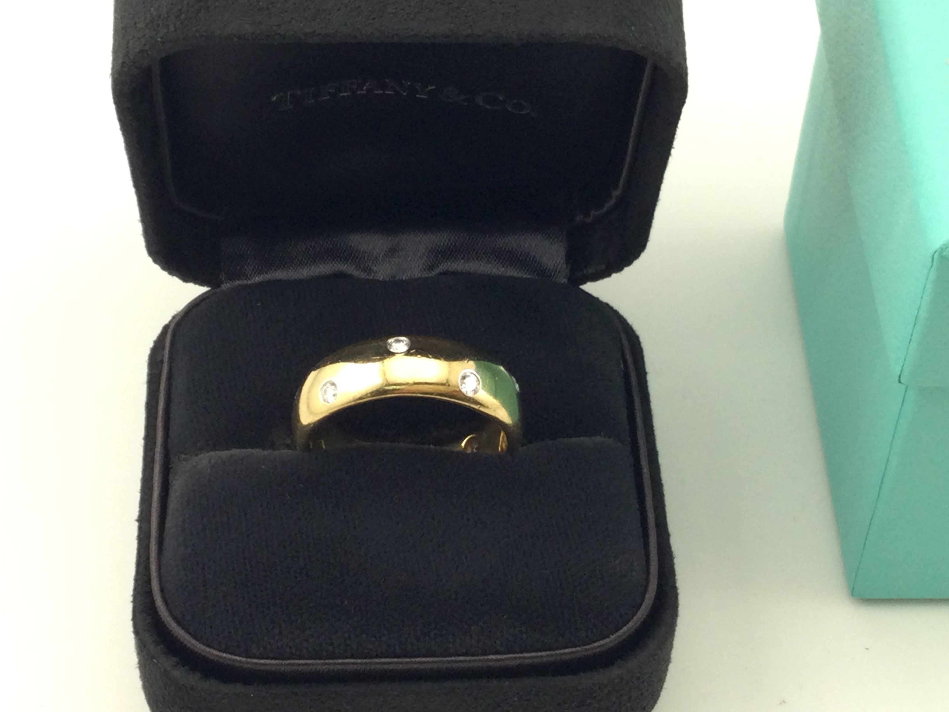 An 18k gold Tiffany and Co gents wedding ring set with diamonds. Size Y and 14.48g. Comes with original ring box and outer box.