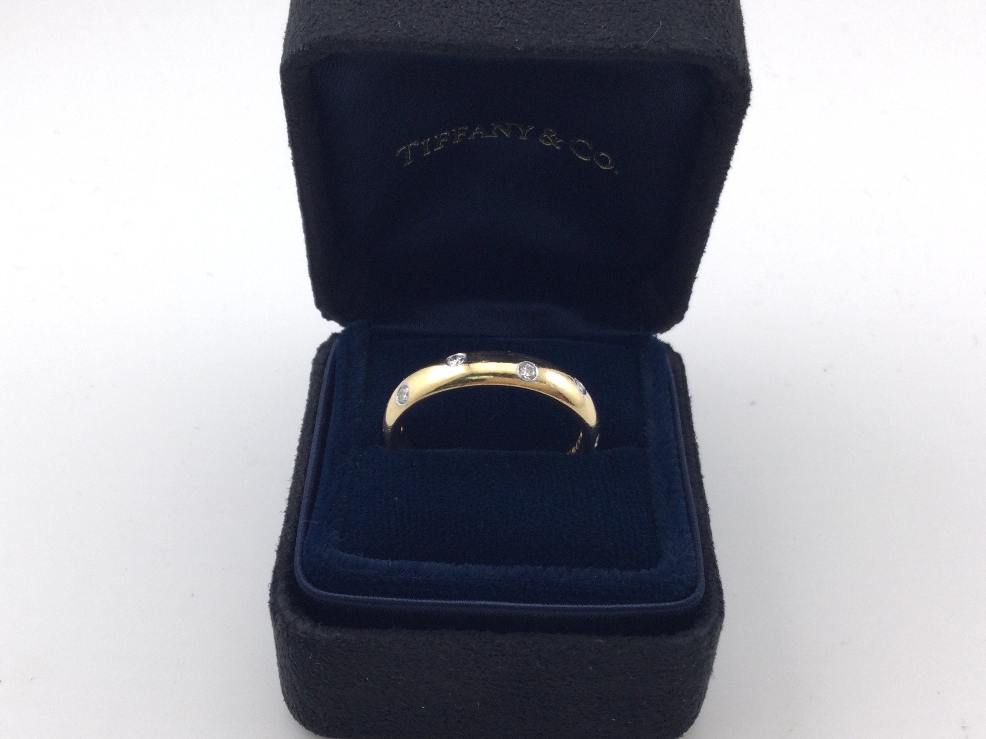 An 18k gold Tiffany and Co wedding ring. Size Q 1/2 and 6.20g. Comes with original inner and outer box.Postage B