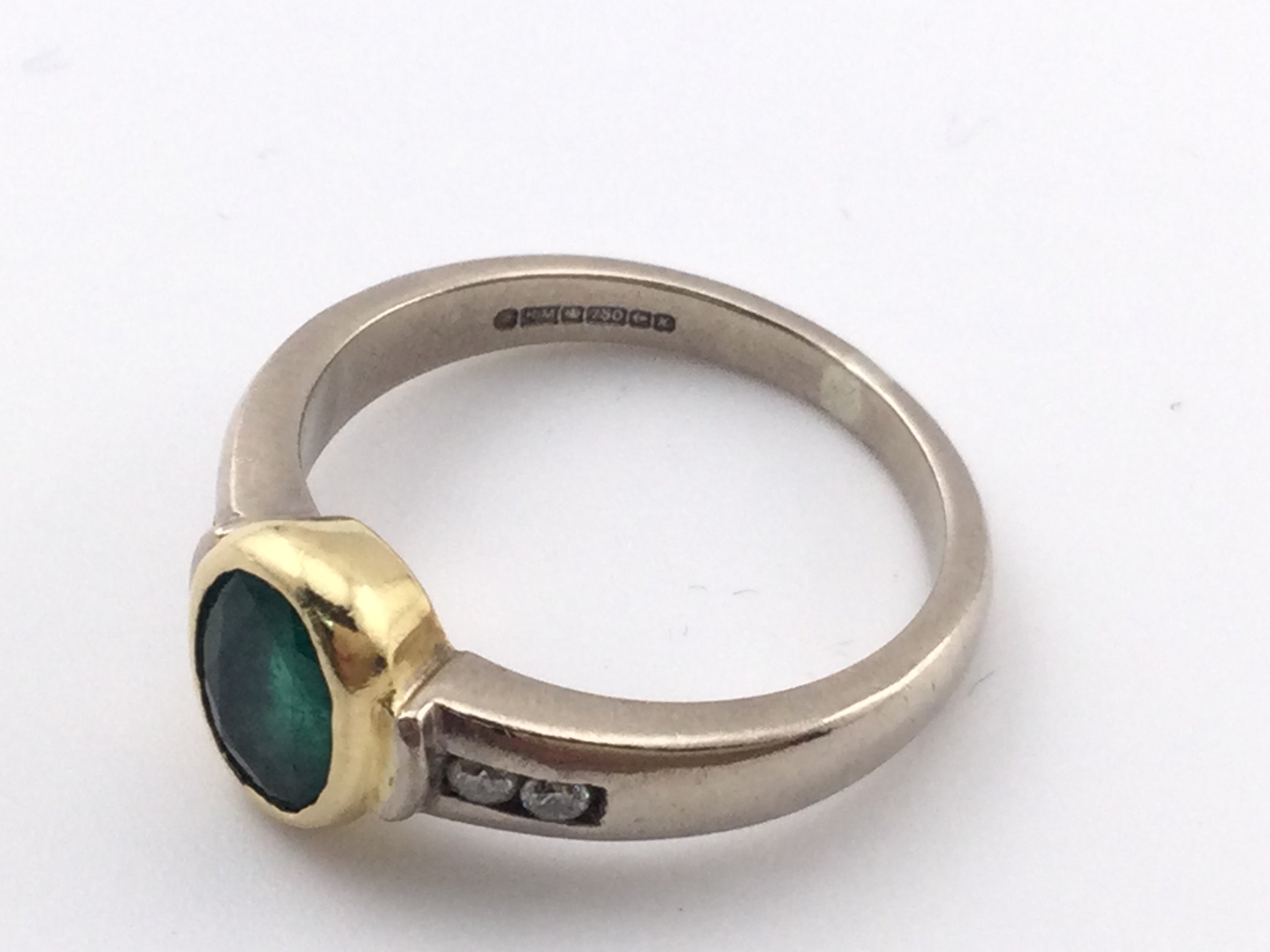 An 18k ring set with central emerald. Size N and 5.53gPostage A