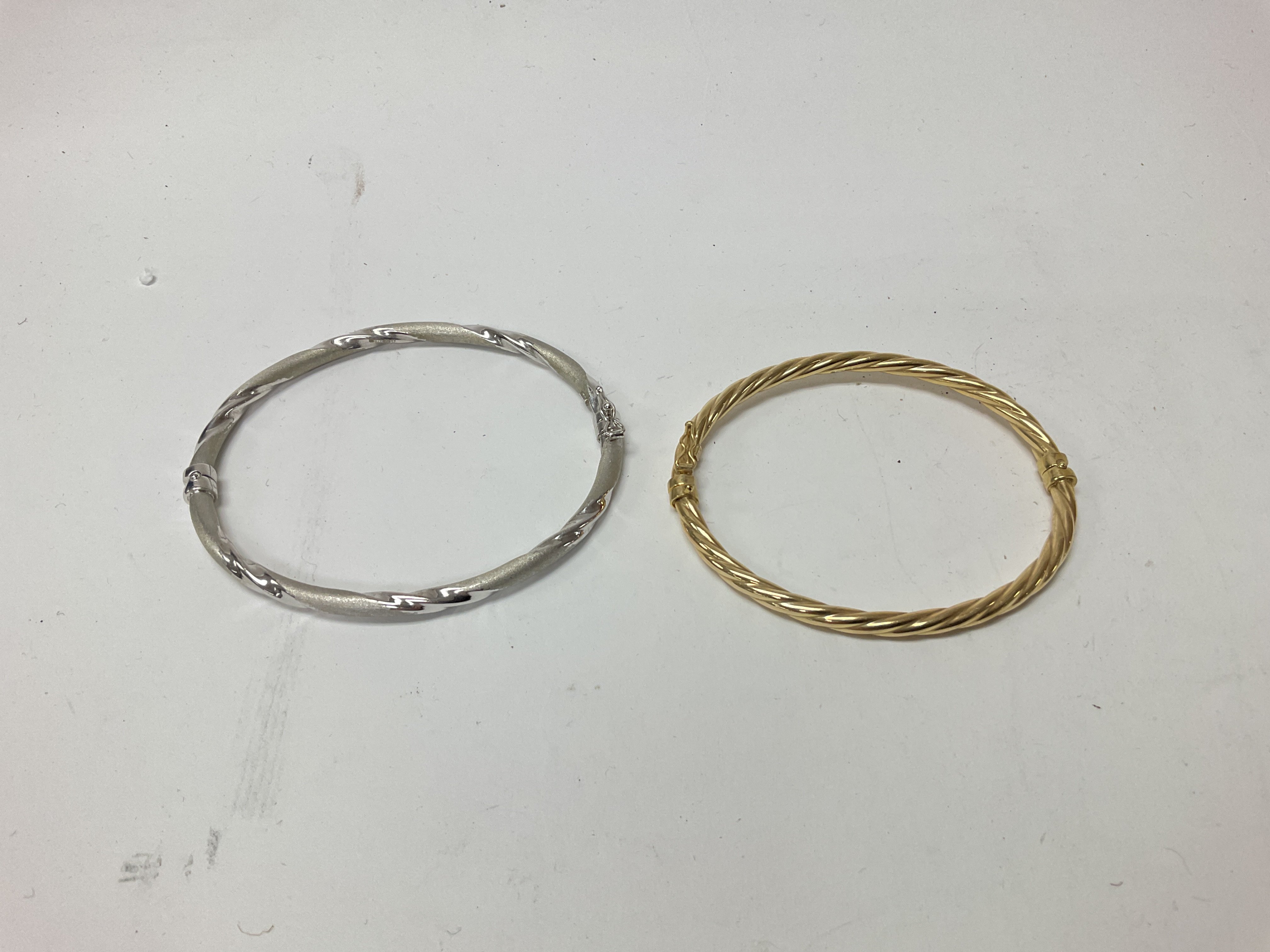 Two 9ct gold hollow bangles, one in white gold and the other in yellow. Approx weight 9.31 grams.