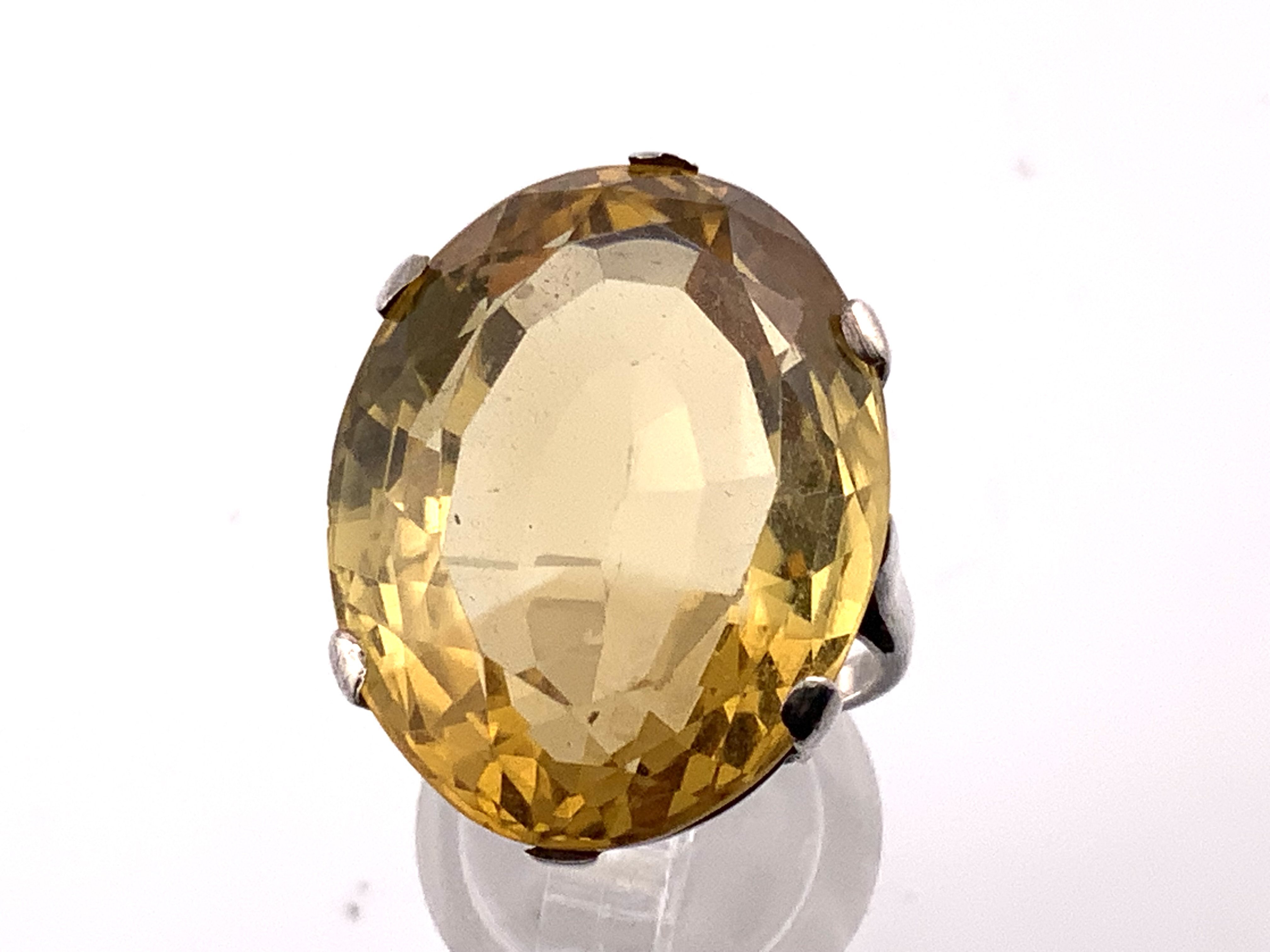 A large approximately 33ct oval cut citrine mounted in a sterling silver ring mount, Size P