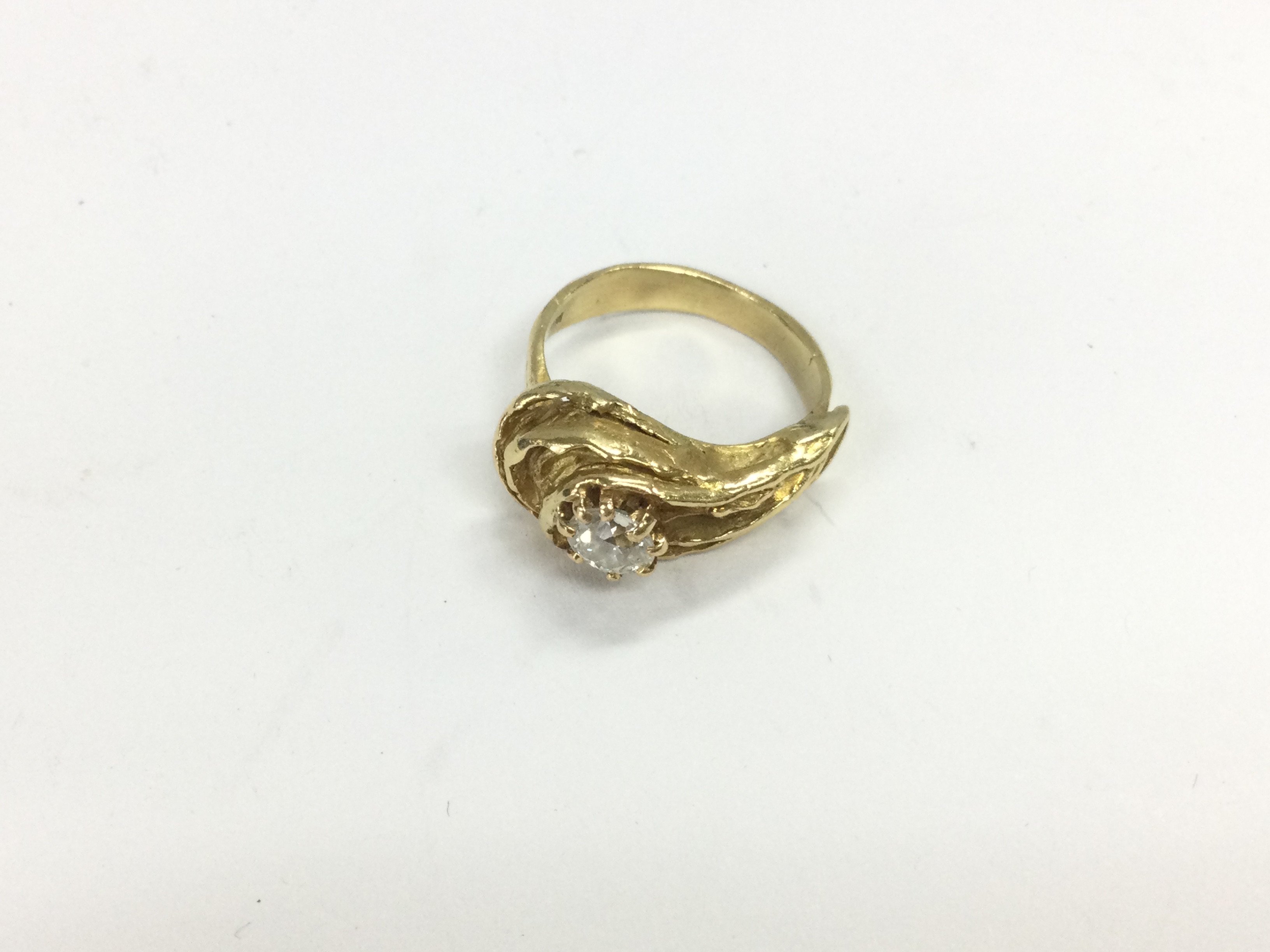 An unusual 18ct gold solitaire ring set with a diamond approx 0.47cts. Approx weight 7.30 grams, approx size J 1/2.