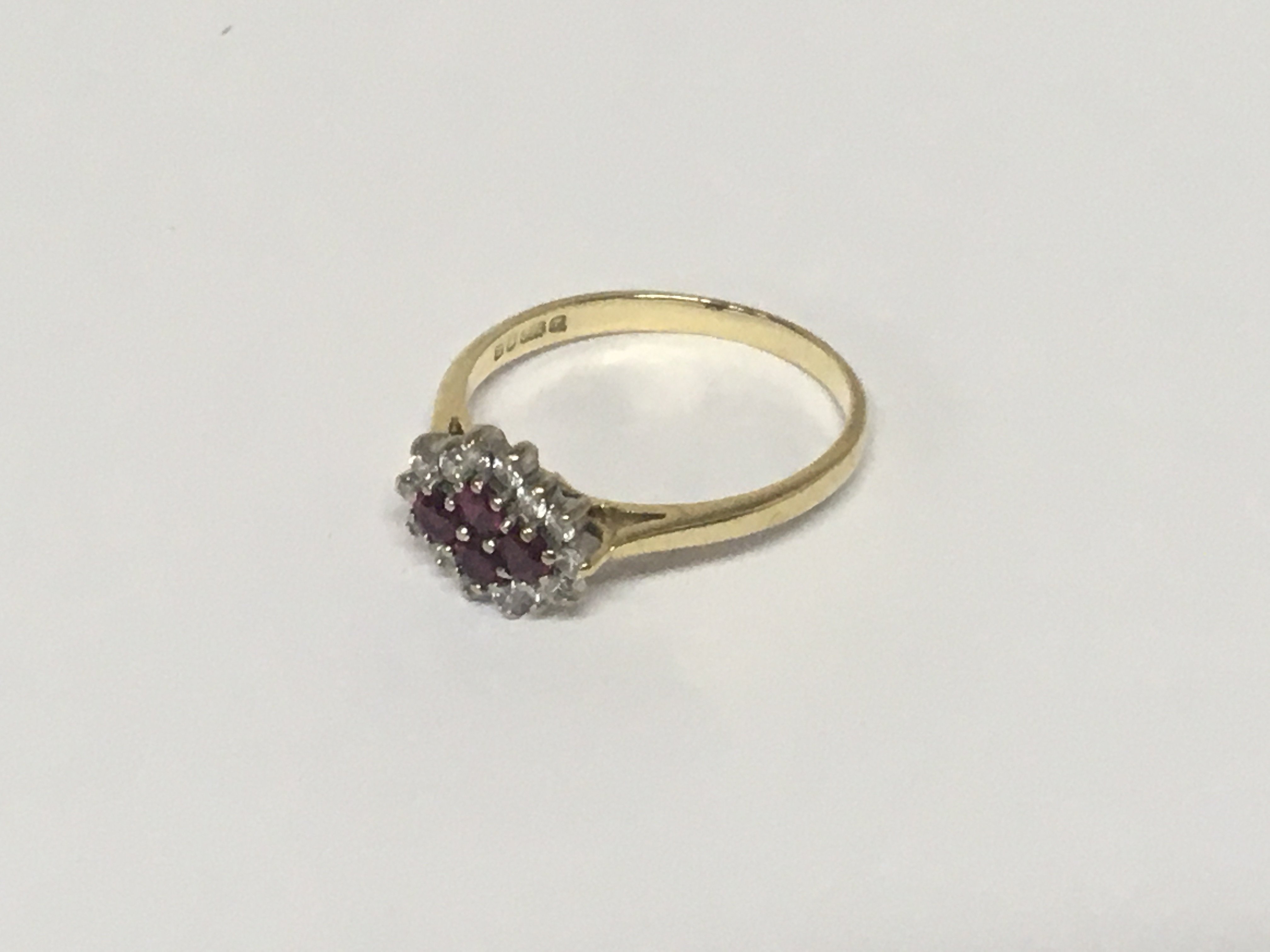 An 18carat gold ring set with a pattern of four ruby flanked by brilliant cut diamonds. Weight 3g ring size R.