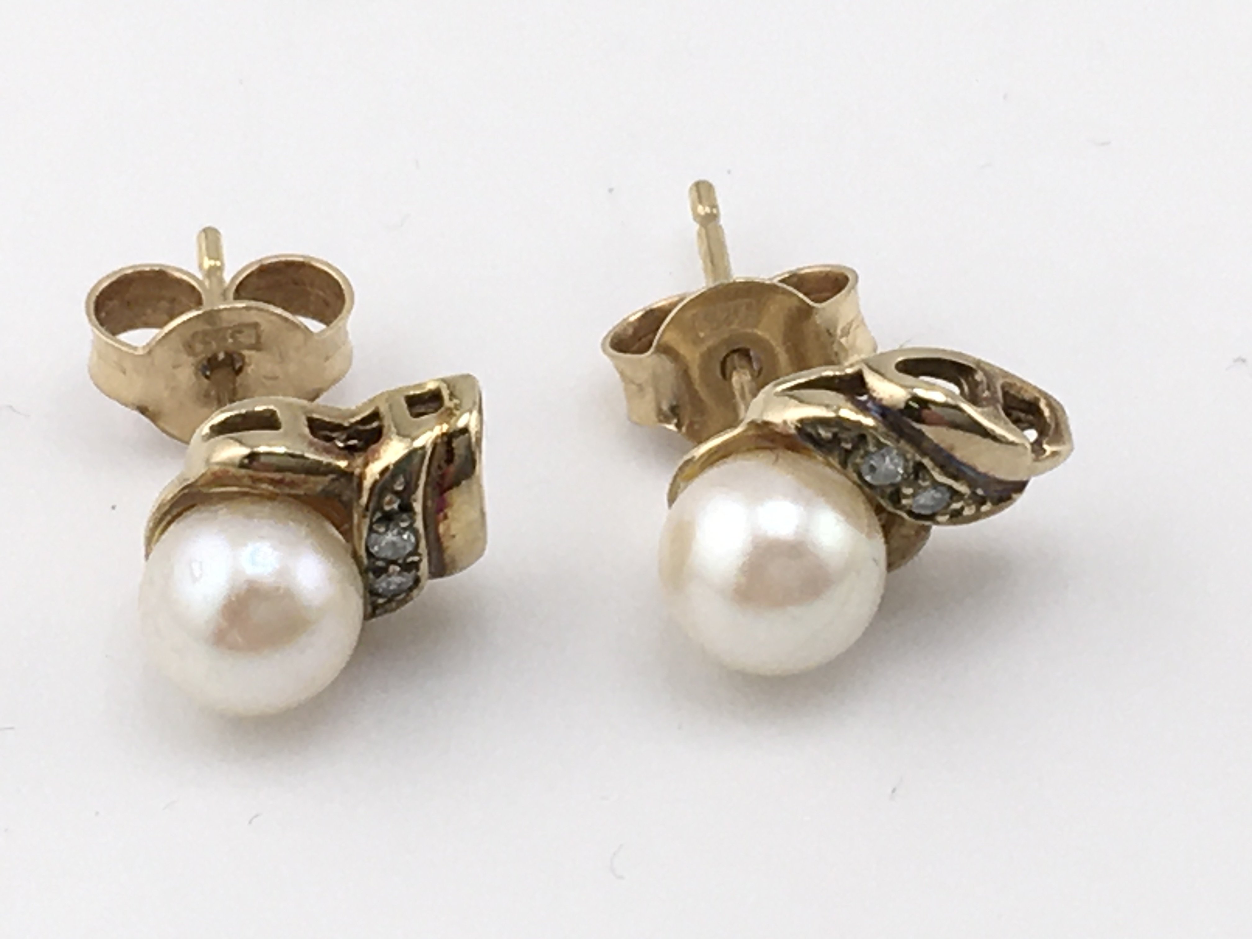 A pair of gold pearl set earrings and a pair of silver earrings set with opal and purple stone. Postage A