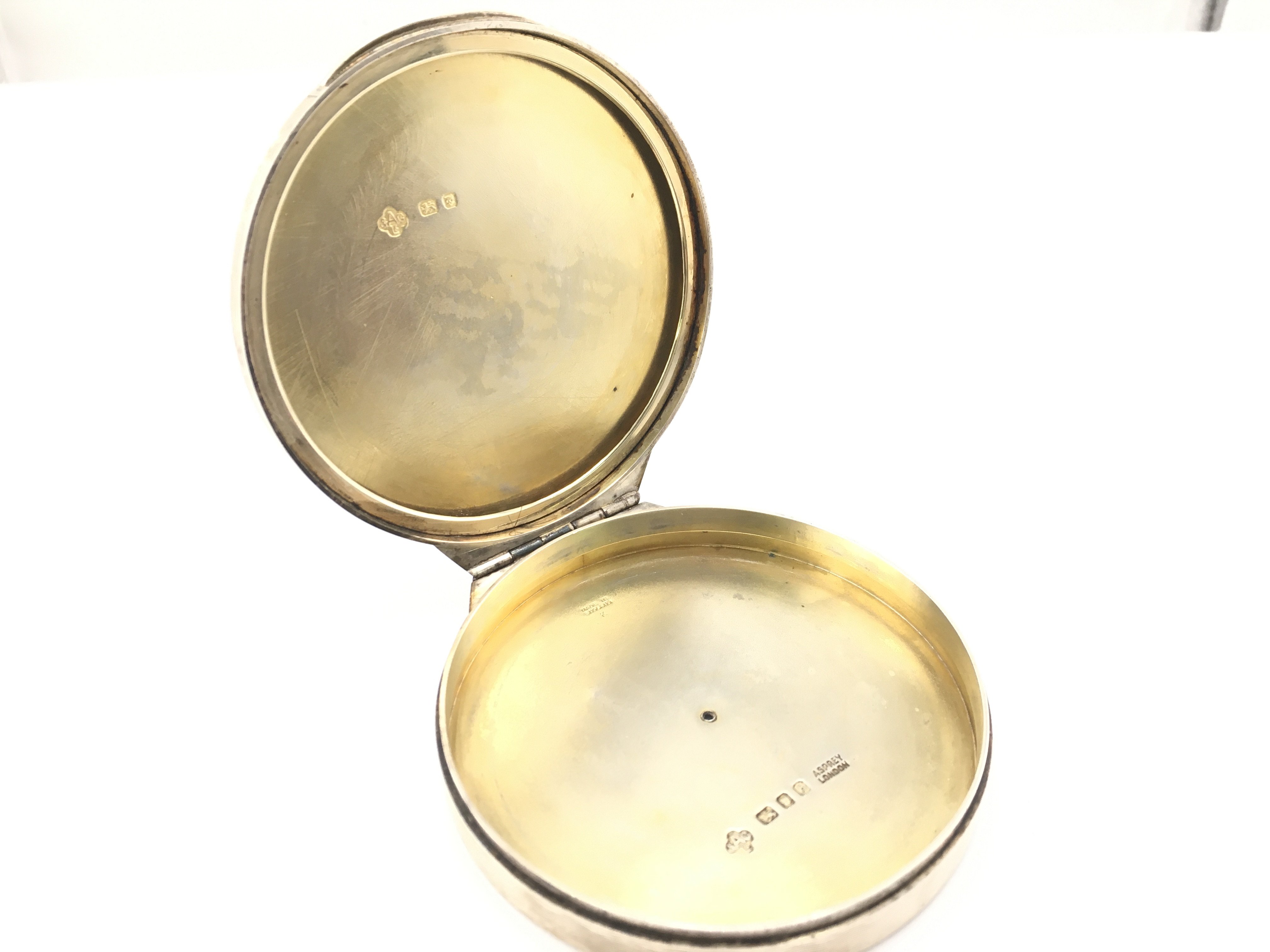 A Silver Asprey circular shaped silver gilt compact, London 1957