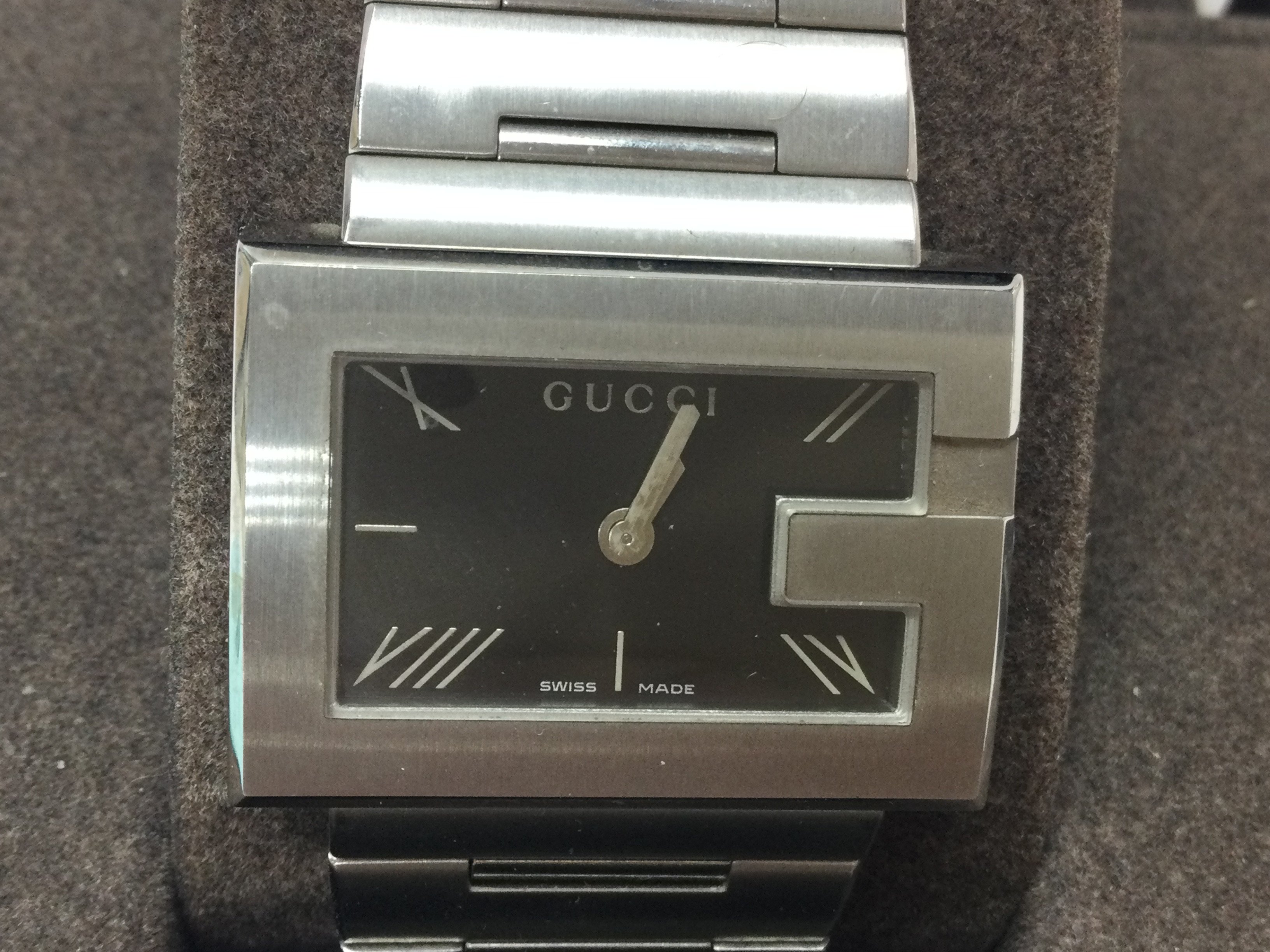 A ladies Gucci stainless steel watch. Black dial with box and papers. Seen running, Postage B
