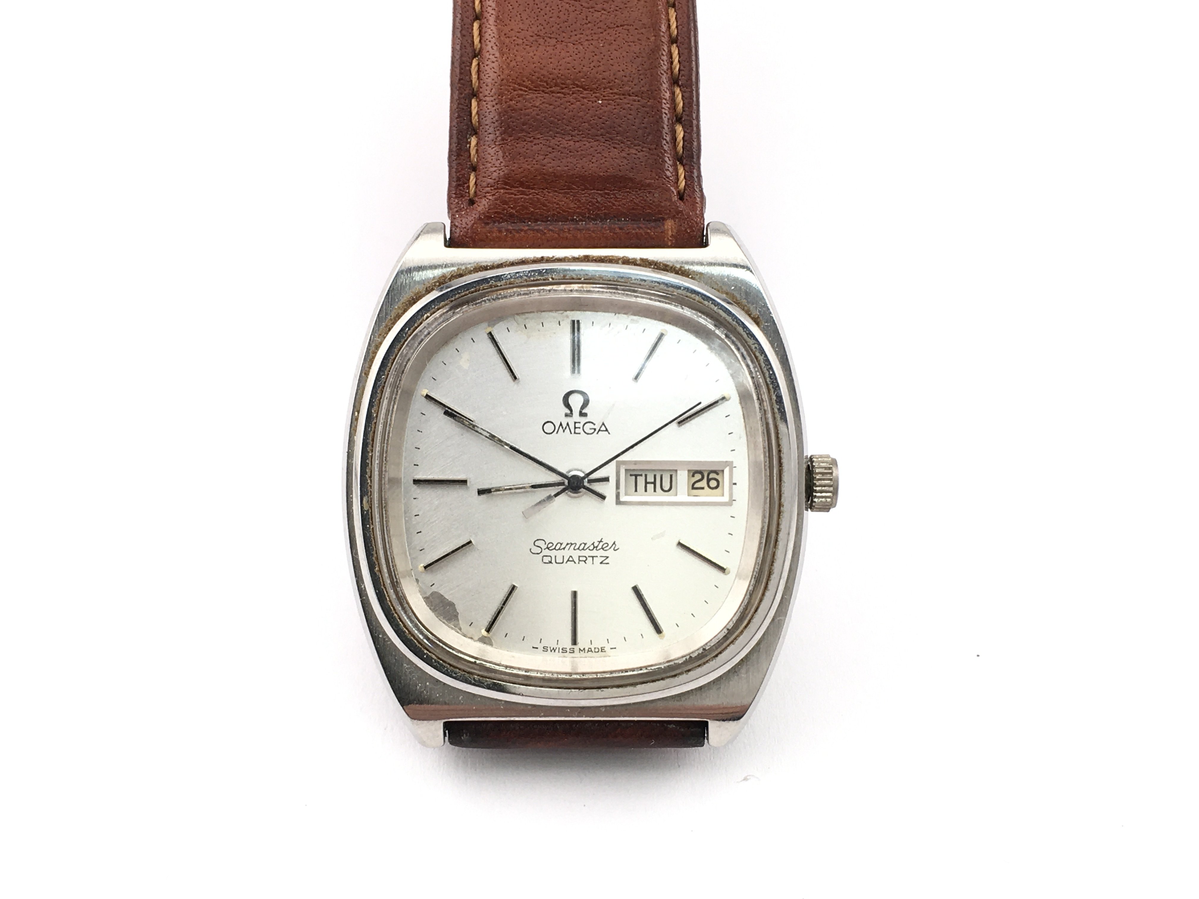 A vintage Omega Seamaster quartz watch with silver dial and brown leather strap. Case approximately 36mm. Not seen running. Postage B