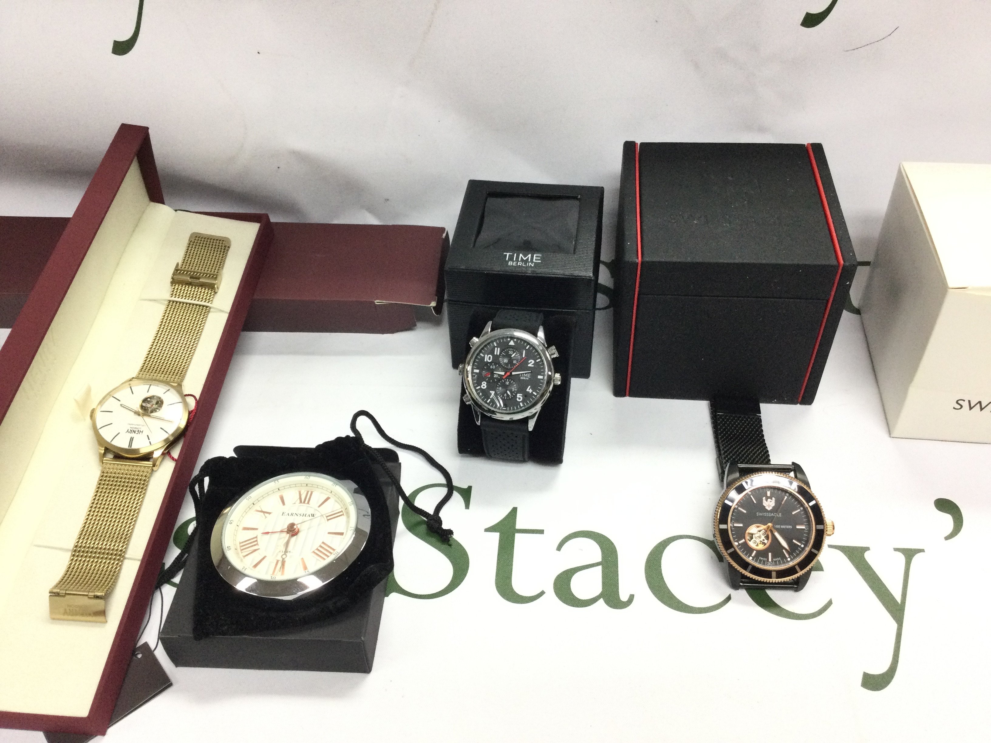 A Swiss eagle gents automatic wrist watch and a Henry of London automatic watch both in excellent condition seen running. Also includes one other watch and a desk clock not seen running. Postage B