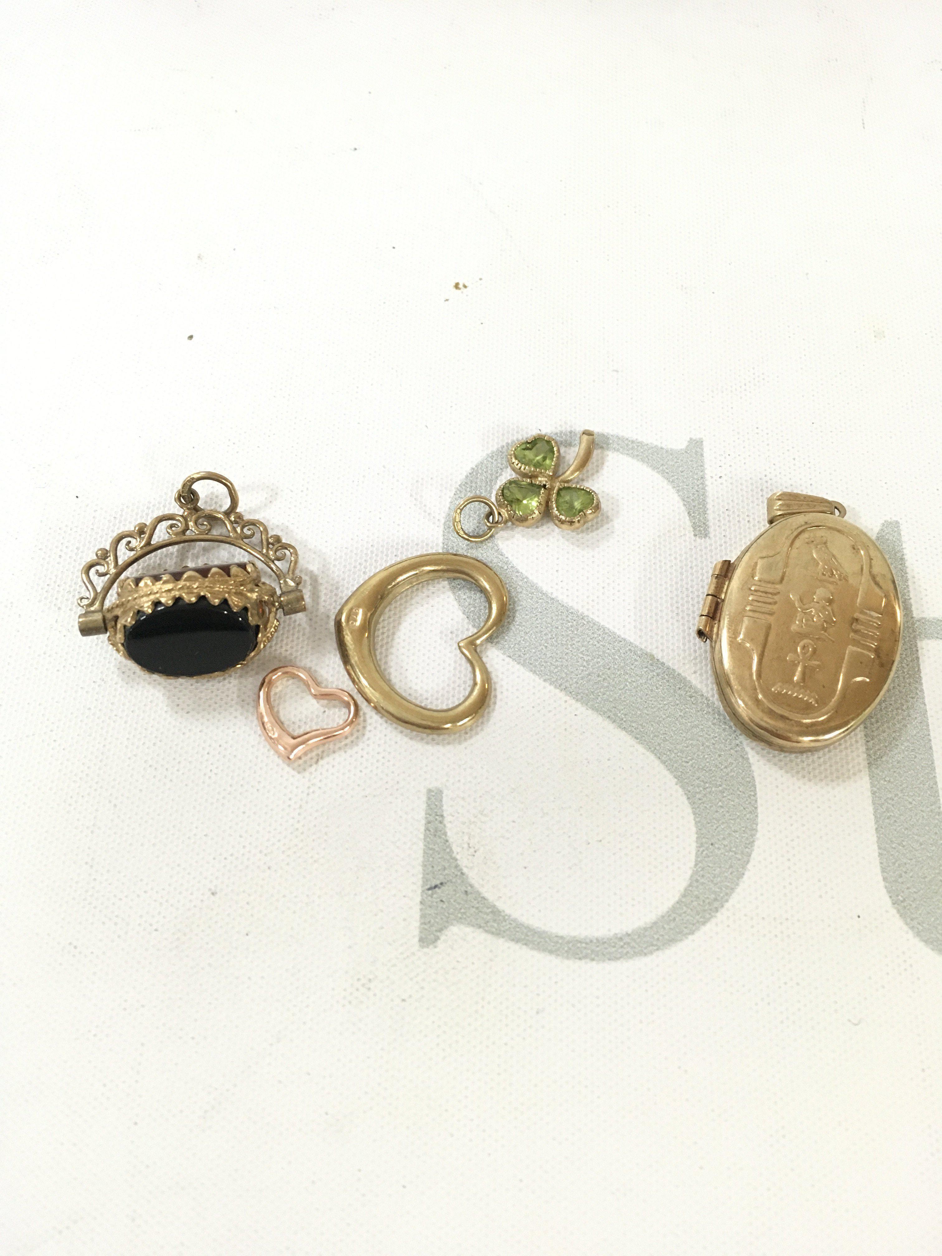 A small collection of 9ct gold charms, fobs and lockets.