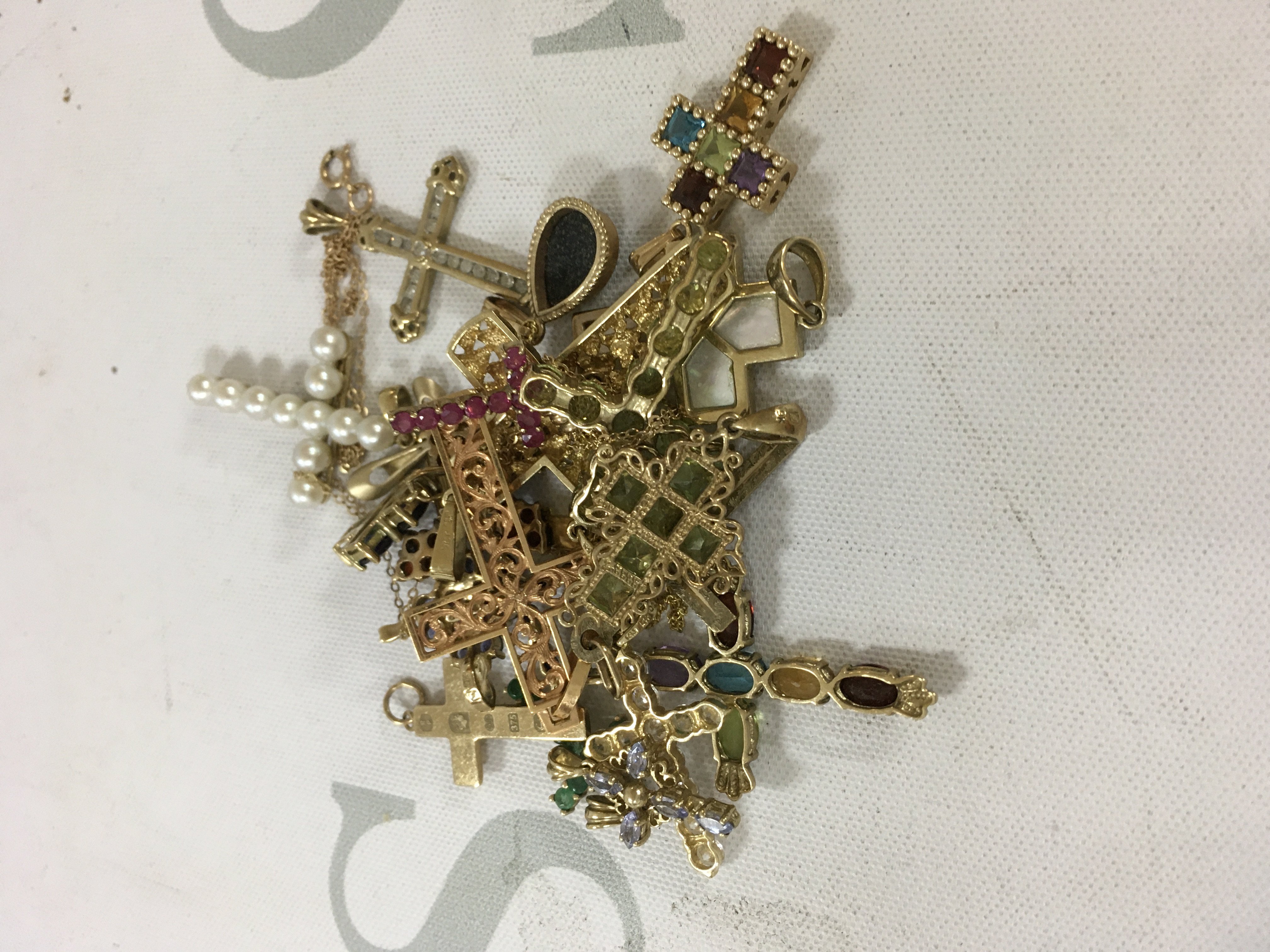 A large collection of gold cross pendants. Approx weight 33.9 grams.