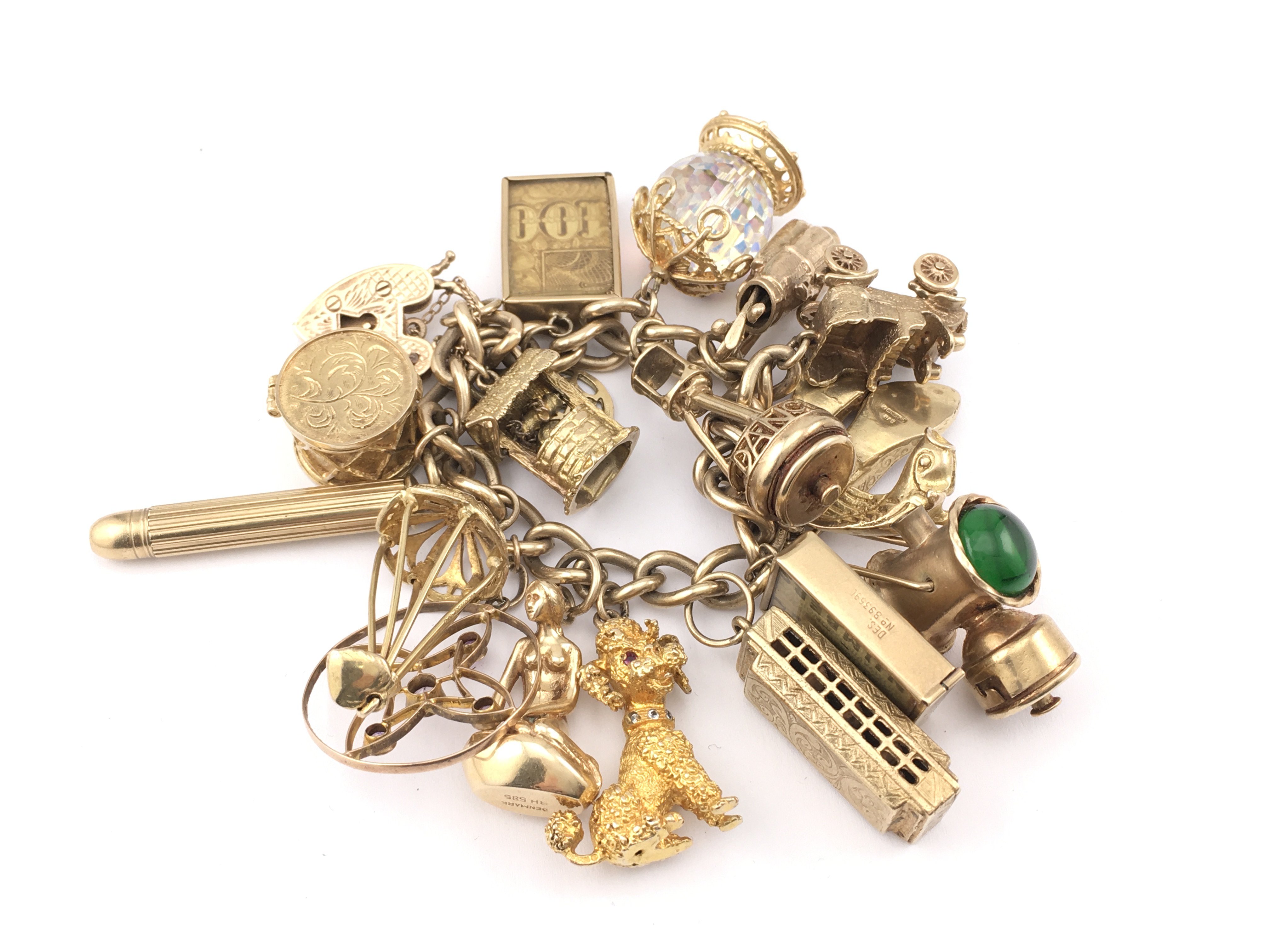 A large 9ct gold charm bracelet set with assorted charms 154.50gPostage B