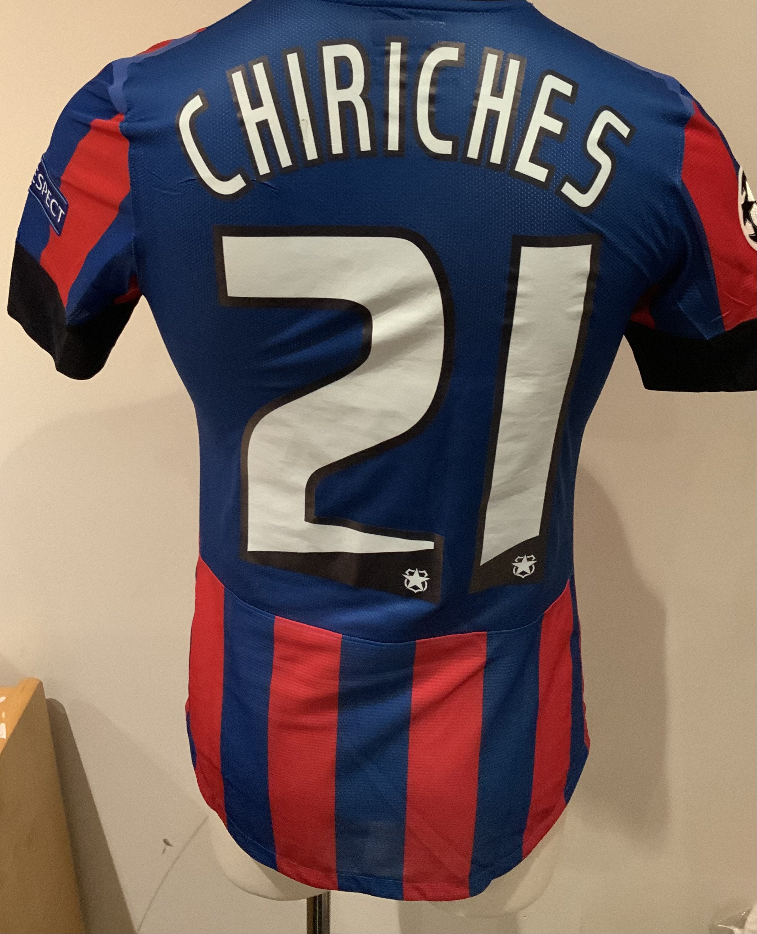 Steaua Bucharest 2013 - 2014 Match Worn Football Shirt: Blue and red short sleeve shirt with Champions League badging to sleeves. Chiriches 21 to rear. Worn during the qualifying campaign. Signed by the player with a dedication. 