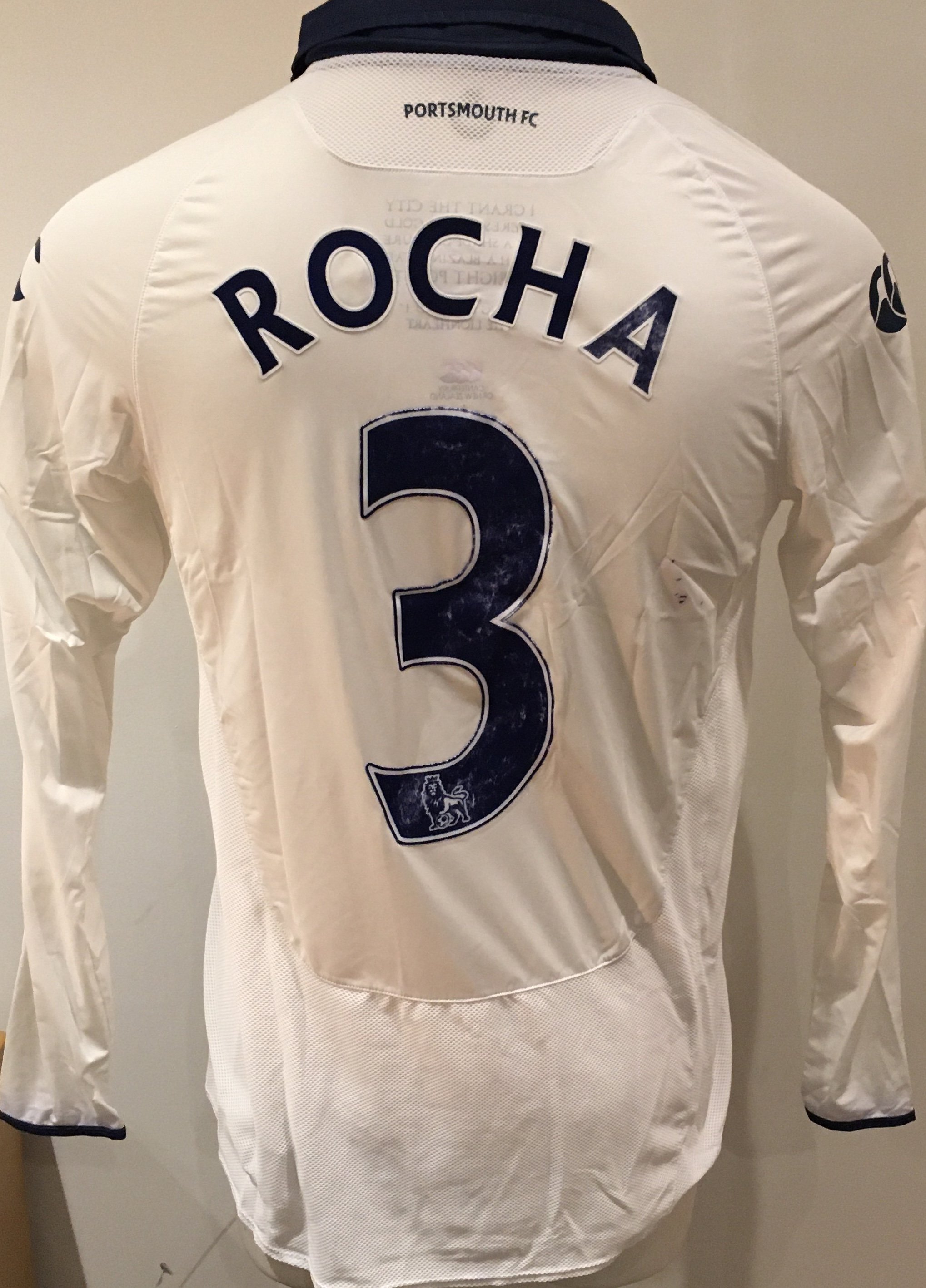 Portsmouth 2009 - 2010 Match Worn Football Shirt:  White long sleeve shirt with Premier League badge to sleeves. Rocha 3 to rear. Signed to front by the player. Some wear to number and staining to rear.