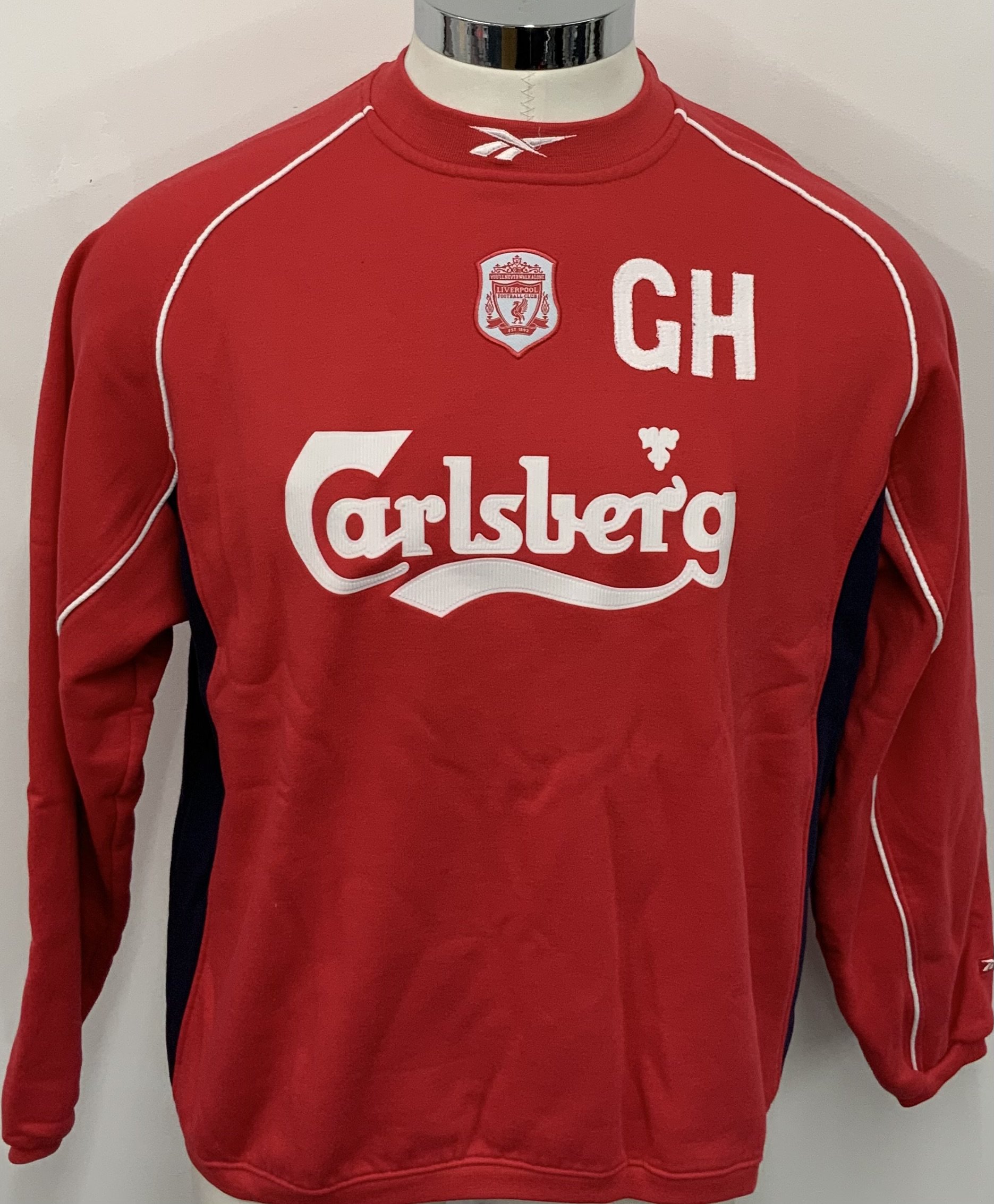 Liverpool 2001 - 2002 Training Top: Red long sleeve Reebok shirt with initials GH to front. Worn by the manager Gerard Houllier. Comes with signed COA from him. 