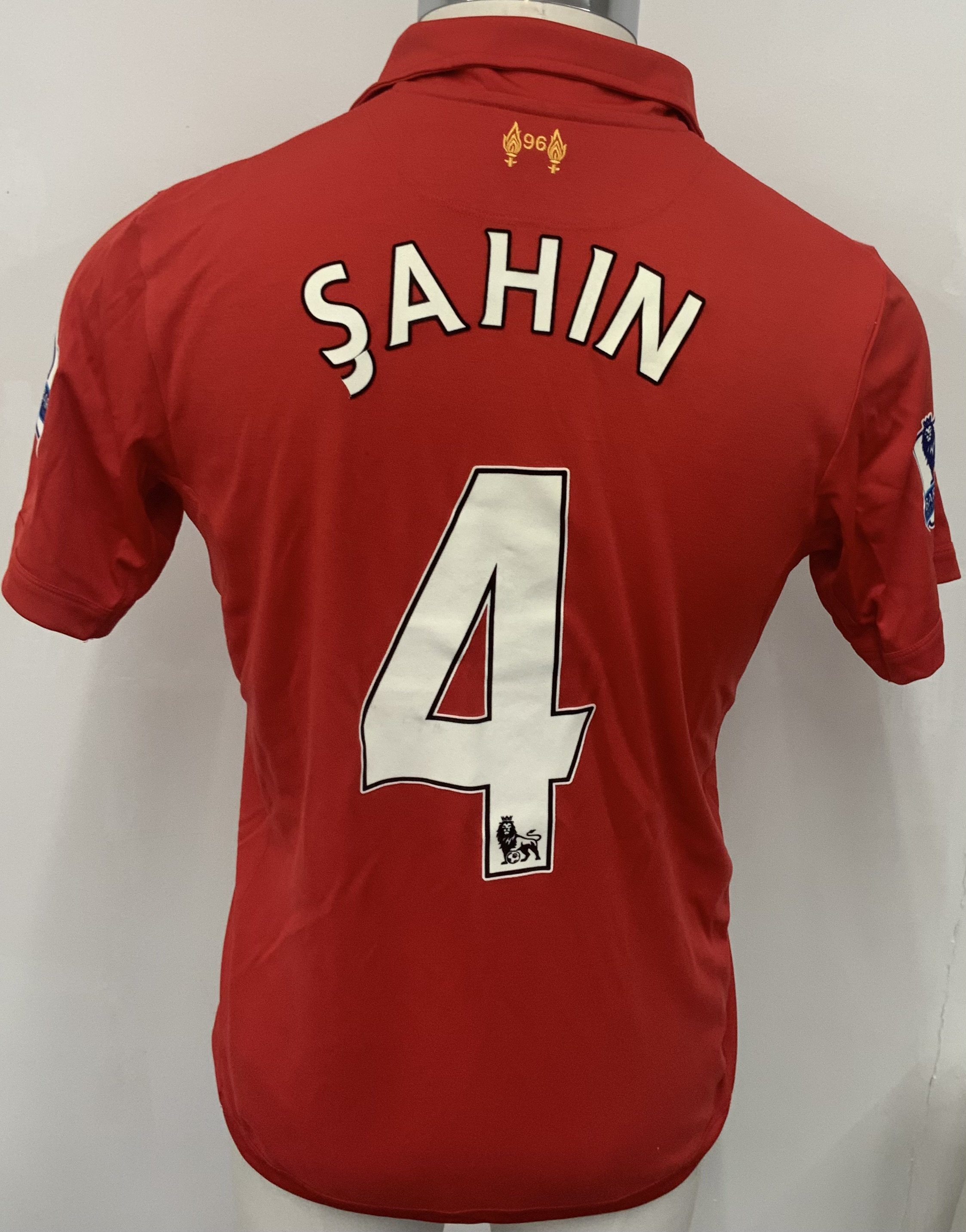 Liverpool 2012 - 2013 Match Worn Poppy Shirt. Red short sleeve shirt with Premier League badging to sleeves. Worn v Chelsea on 11 November 2012 by Sahin 4. Shirt is squad signed to the front and comes with COA from Liverpool FC to cover autographs. 