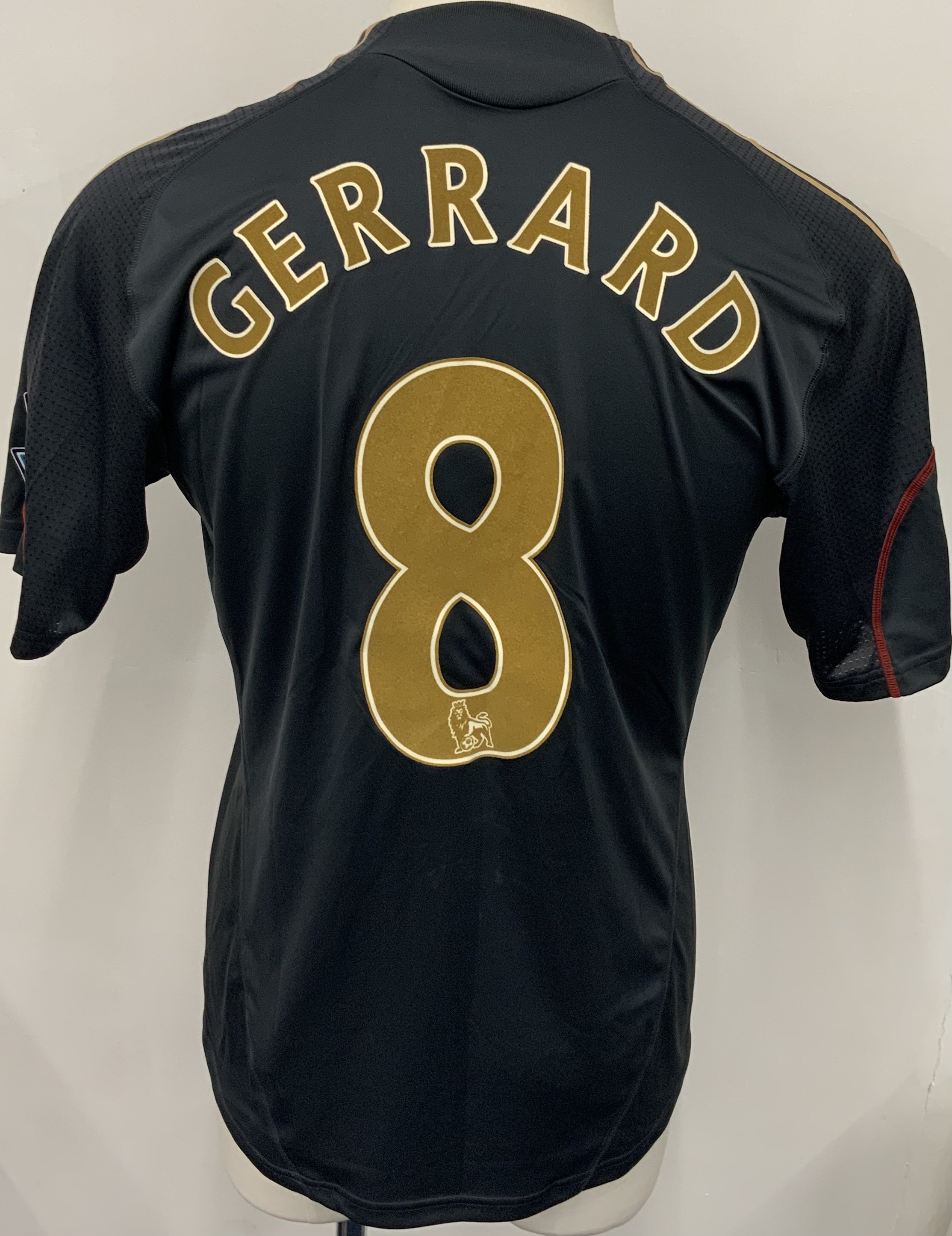 Liverpool 2009 - 2010 Match Worn Signed Football Shirt: Black Carlsberg Adidas short sleeve shirt with gold and red trim. Number 8 Gerrard to rear. Signed and dedicated to front by Gerrard.
