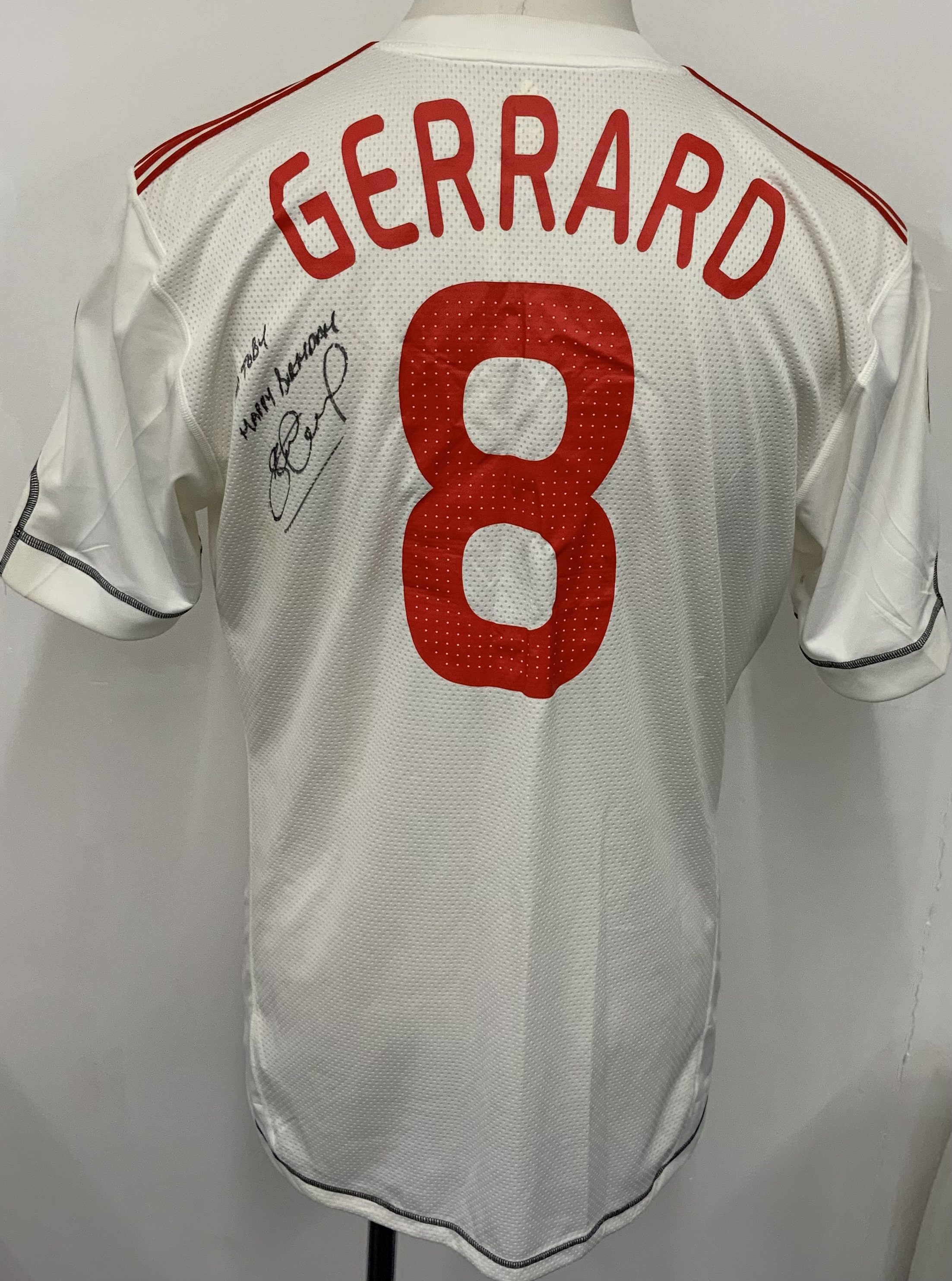 Liverpool 2009 - 2010 Match Worn Signed Football Shirt: White Carlsberg Adidas short sleeve shirt with Champions League badging. Number 8 Gerrard to rear. Signed and dedicated to rear by Gerrard. Worn v Fiorentina. 