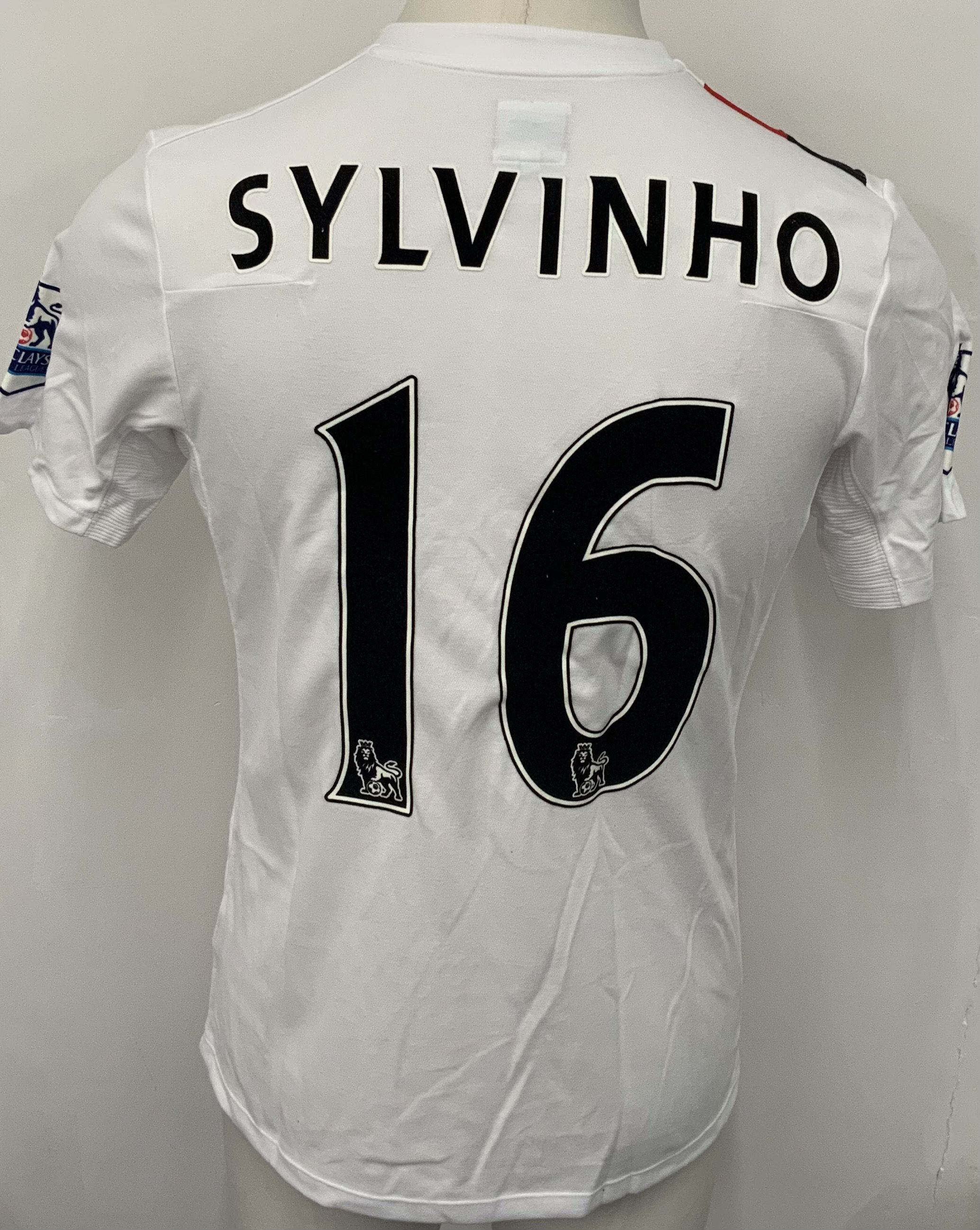 Manchester City 2009 - 2010 Sylvinho 3rd Kit Match Issued Football Shirt: White with red and black slash short sleeve Umbro shirt from 1st season of Etihad Sponsorship. Premier League badging to sleeve and Sylvinho 16 to rear. 