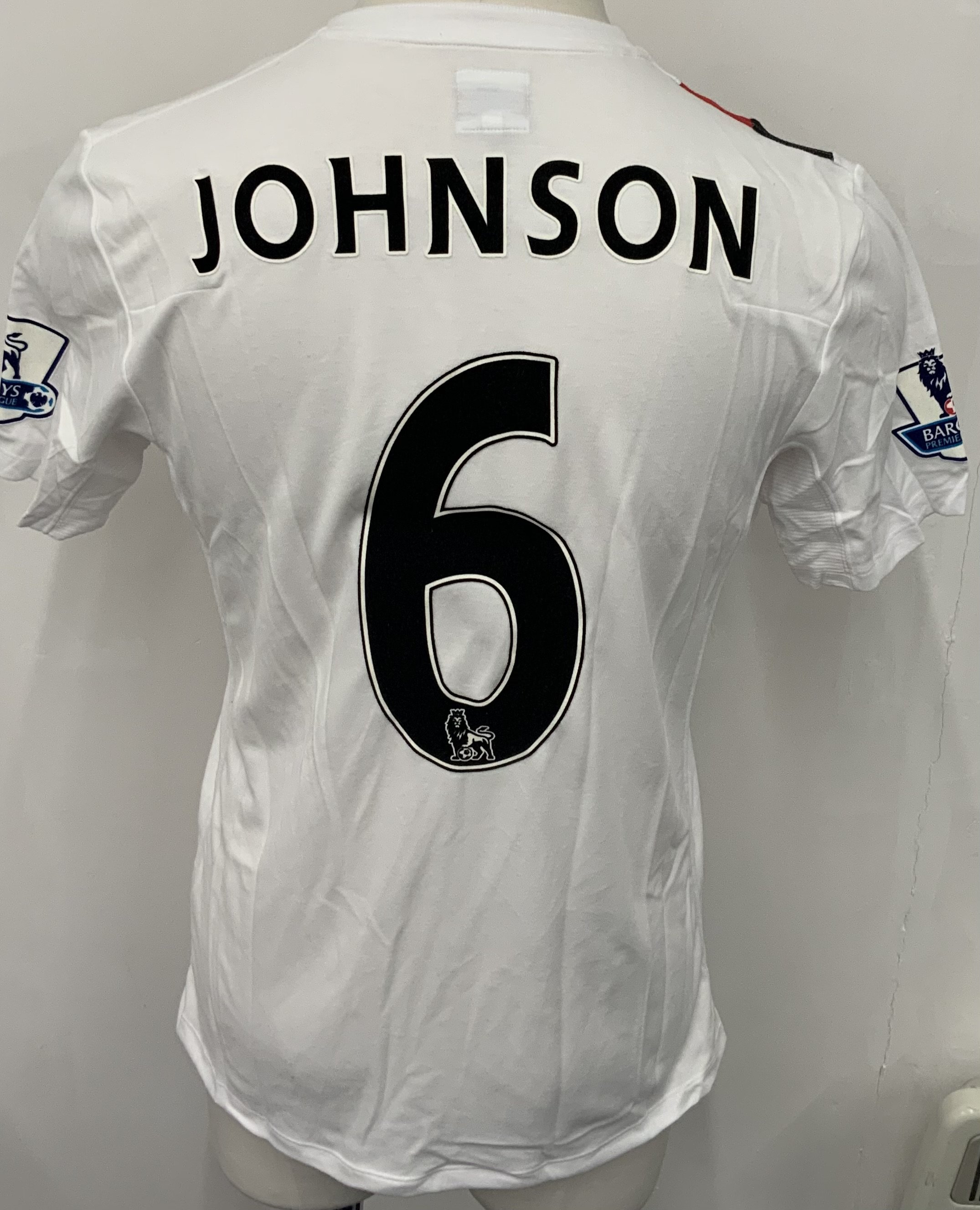 Manchester City 2009 - 2010 M Johnson 3rd Kit Match Issued Football Shirt: White with red and black slash short sleeve Umbro shirt from 1st season of Etihad Sponsorship. Premier League badging to sleeve and Johnson 6 to rear. 