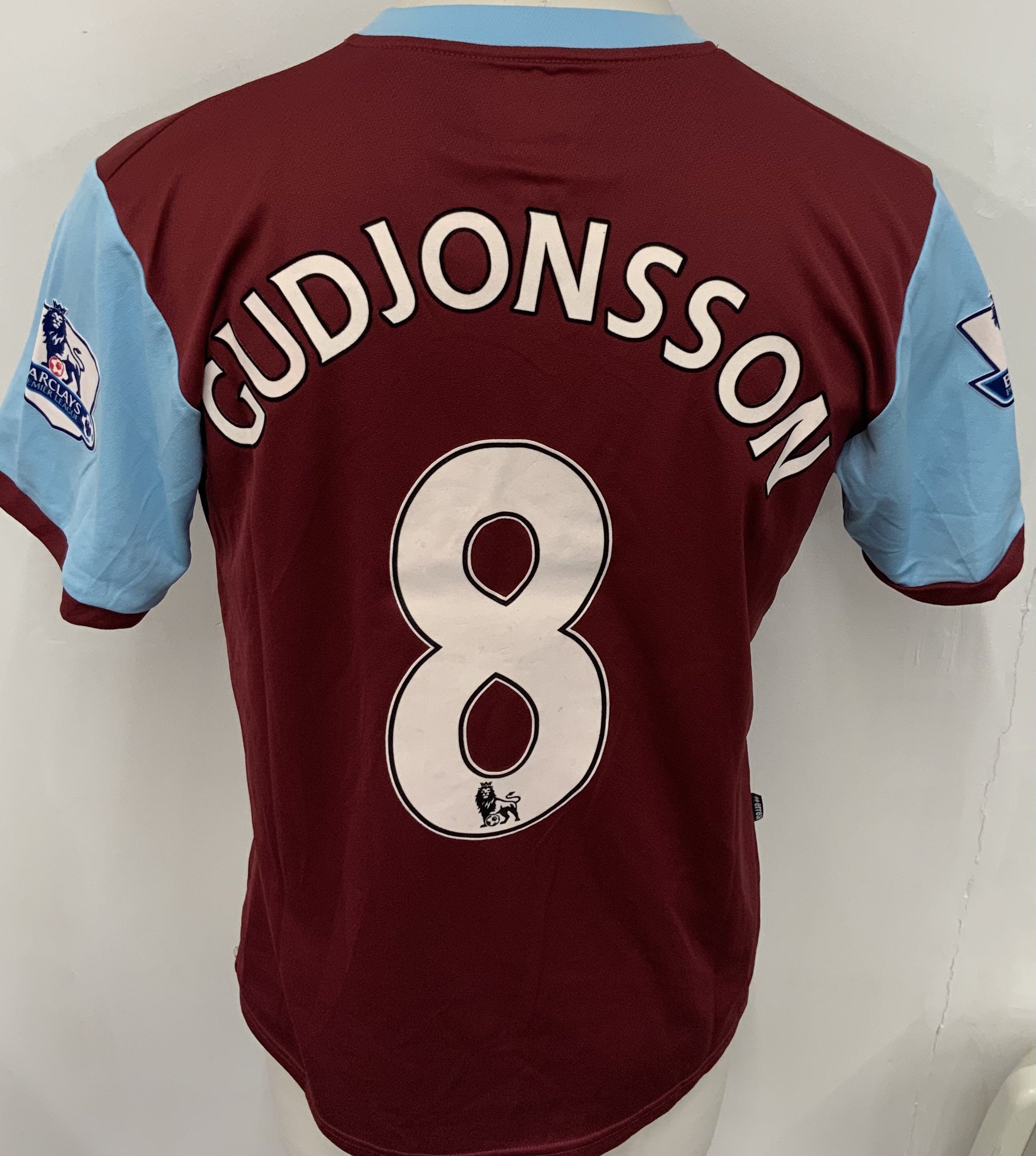 Burnley 2009 - 2010 Match Worn Football Shirt: Claret and blue short sleeve shirt. Number 8 Gudjonsson. Premier League badging. Worn v Arsenal on 16 December 2009. Match finished 1-1.