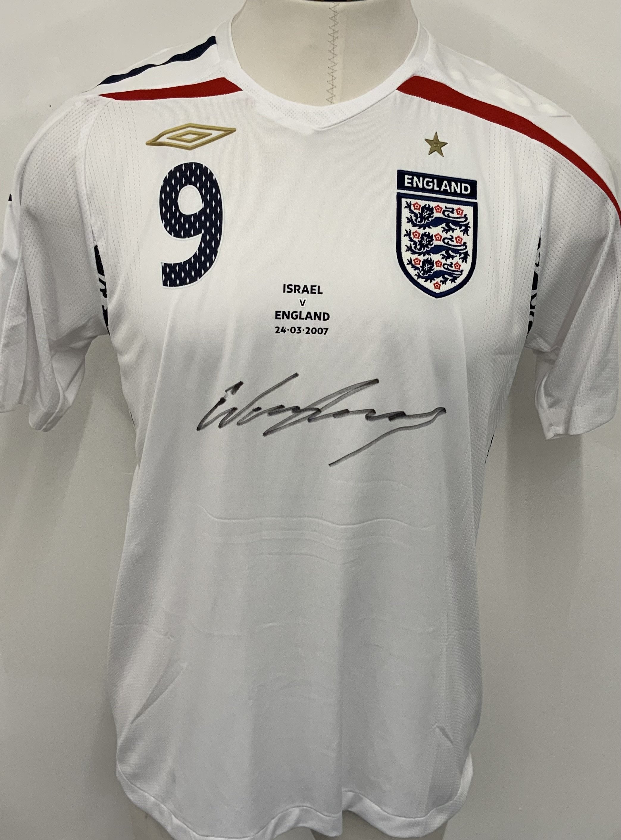 England 2006 - 2007 Rooney Match Issued England Football Shirt: White short sleeve Umbro shirt with number 9 Rooney to rear. Issued v Israel on 24 March 2007.  Shirt is signed to the front by player. 