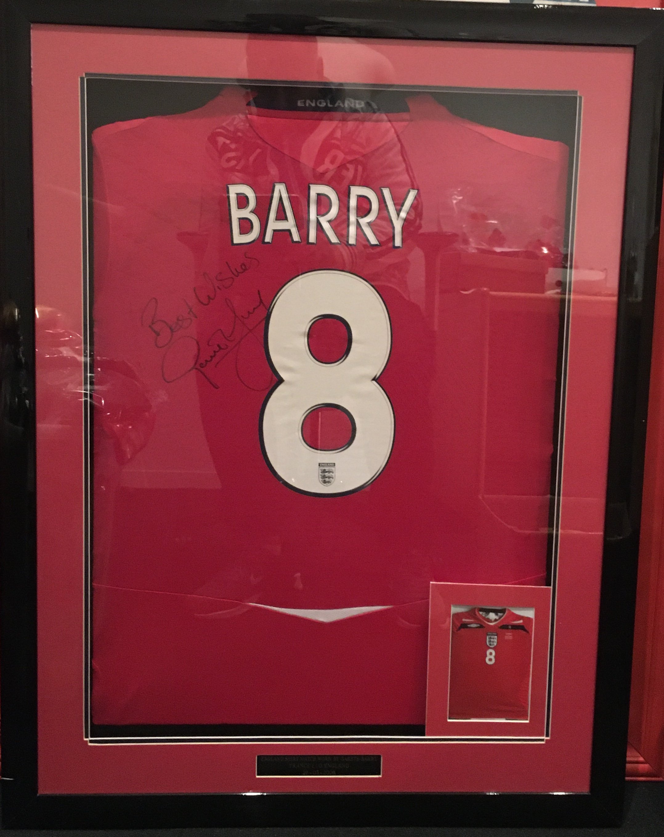 2008 Gareth Barry Match Worn England Framed Football Shirt: Red away  shirt with number 8 Barry to rear. Signed best wishes Gareth Barry next to number 8. Expensively framed in deep frame. Plaque at the bottom states England Shirt Match Worn By Gareth Barry France 1 England 0 26 3 2008. Not for posting. 