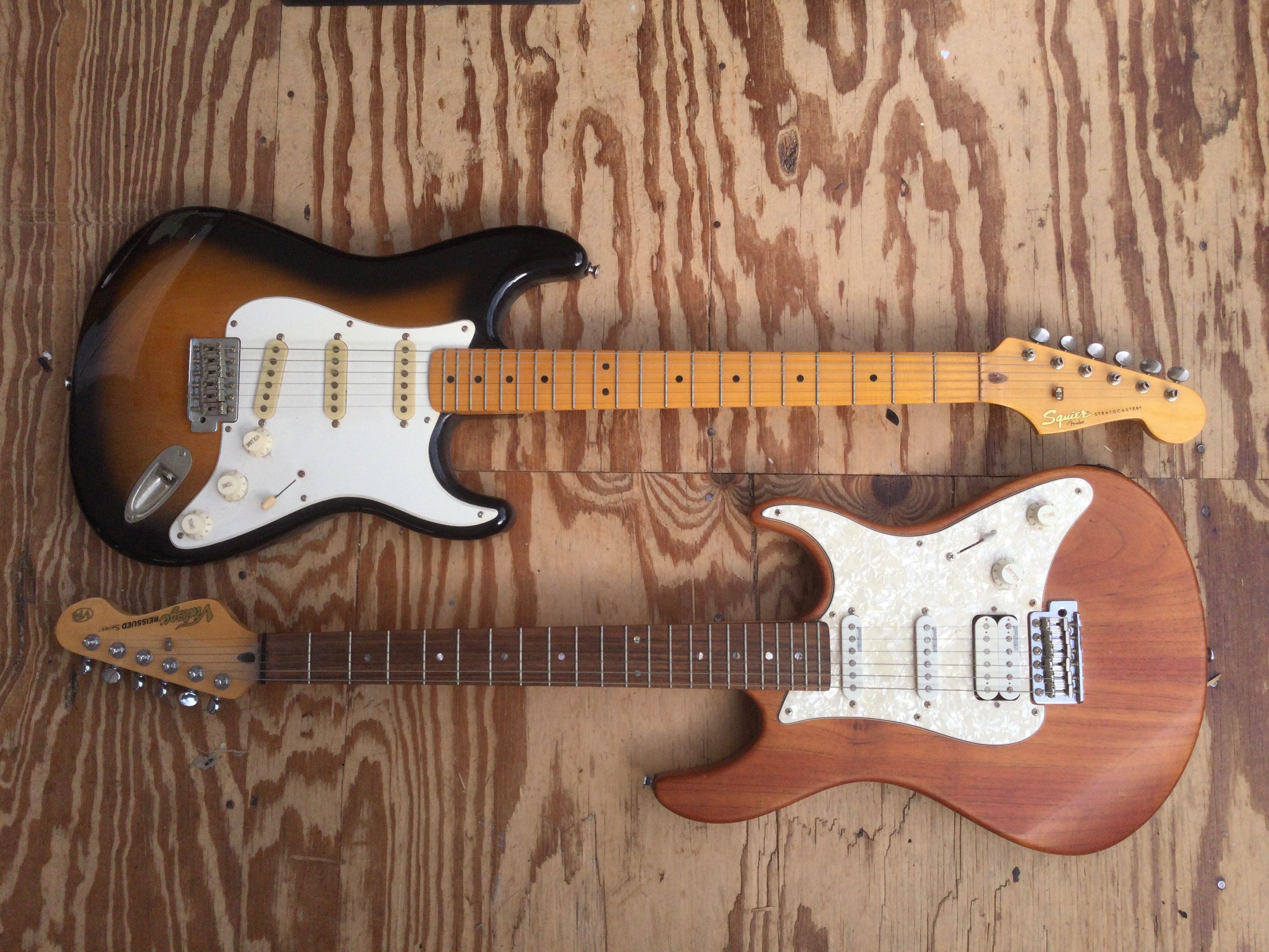 Two Stratocaster style electric guitars comprising a Fender Squier and a Vintage Reissued series example plus a Laney practice amp and a guitar stand (4).