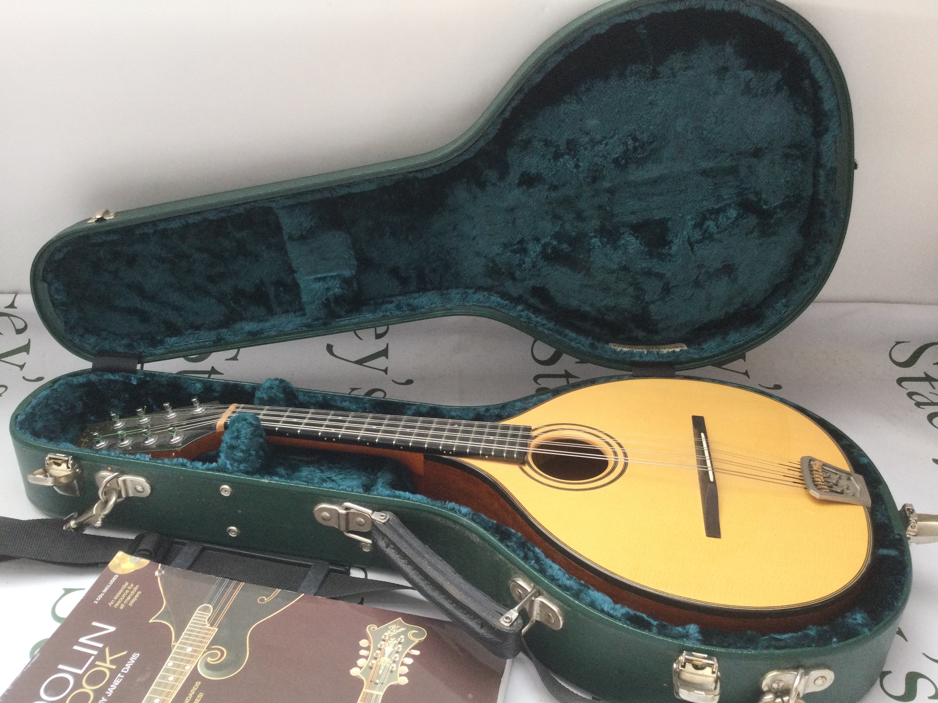 A fine quality Fylde mandolin with hard carry case and a mandolin songbook.