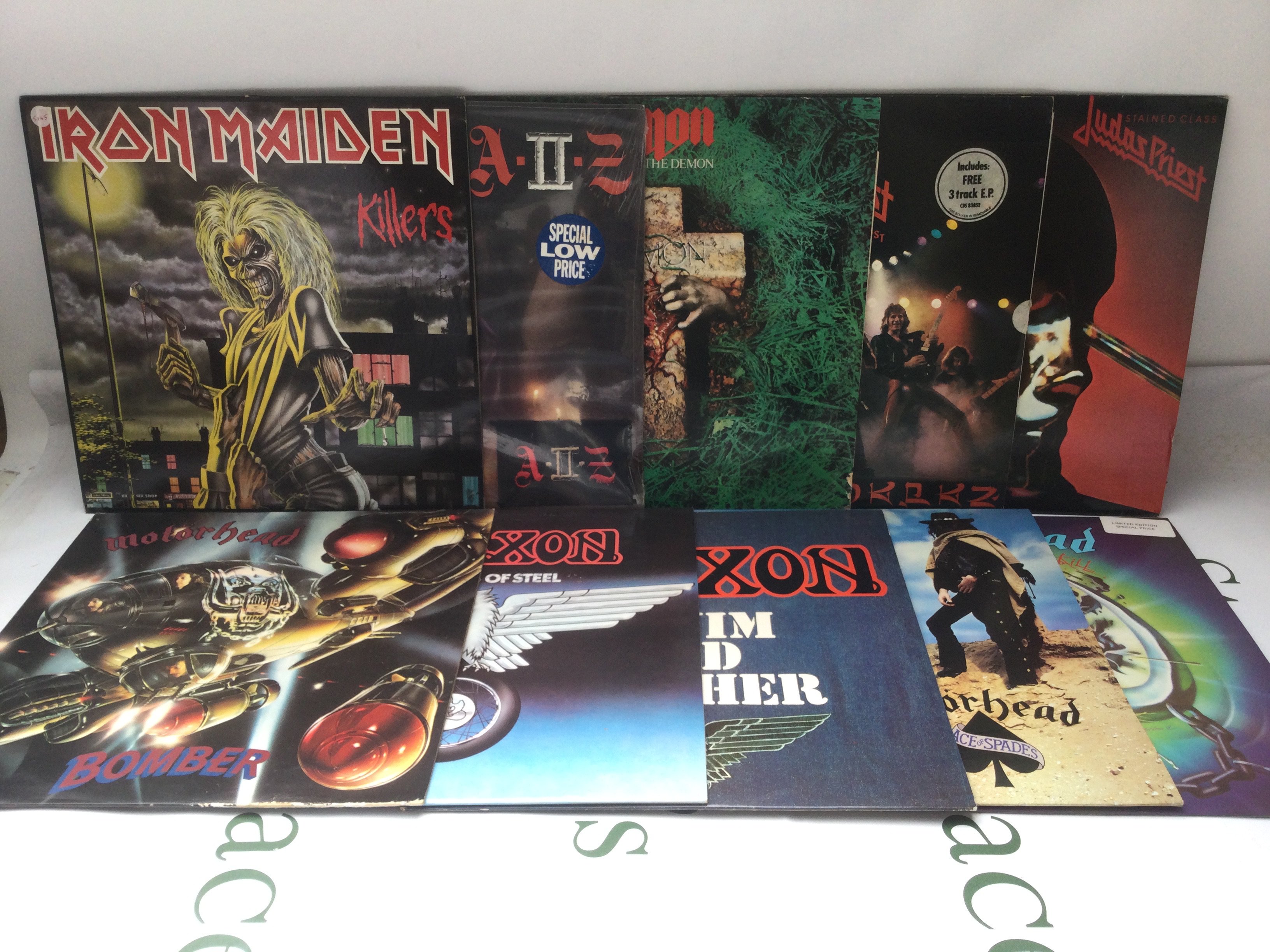 Two bags containing twenty heavy rock LPs by various artists including Iron Maiden, Led Zeppelin, Black Sabbath and others. Includes two Judas Priest promo discs.