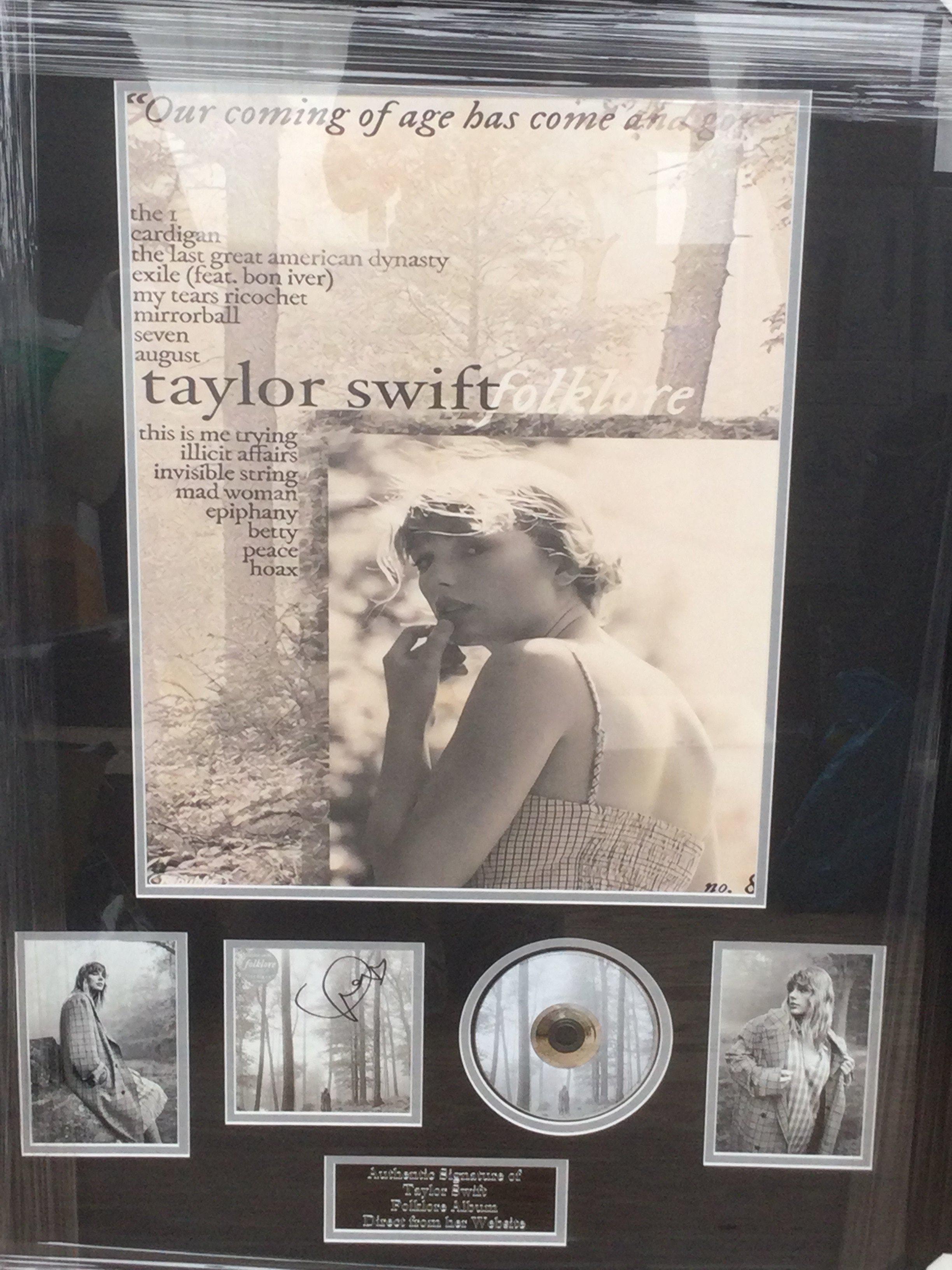A framed snd glazed signed Taylor Swift display for Folklore, approx 92cm x 70cm.