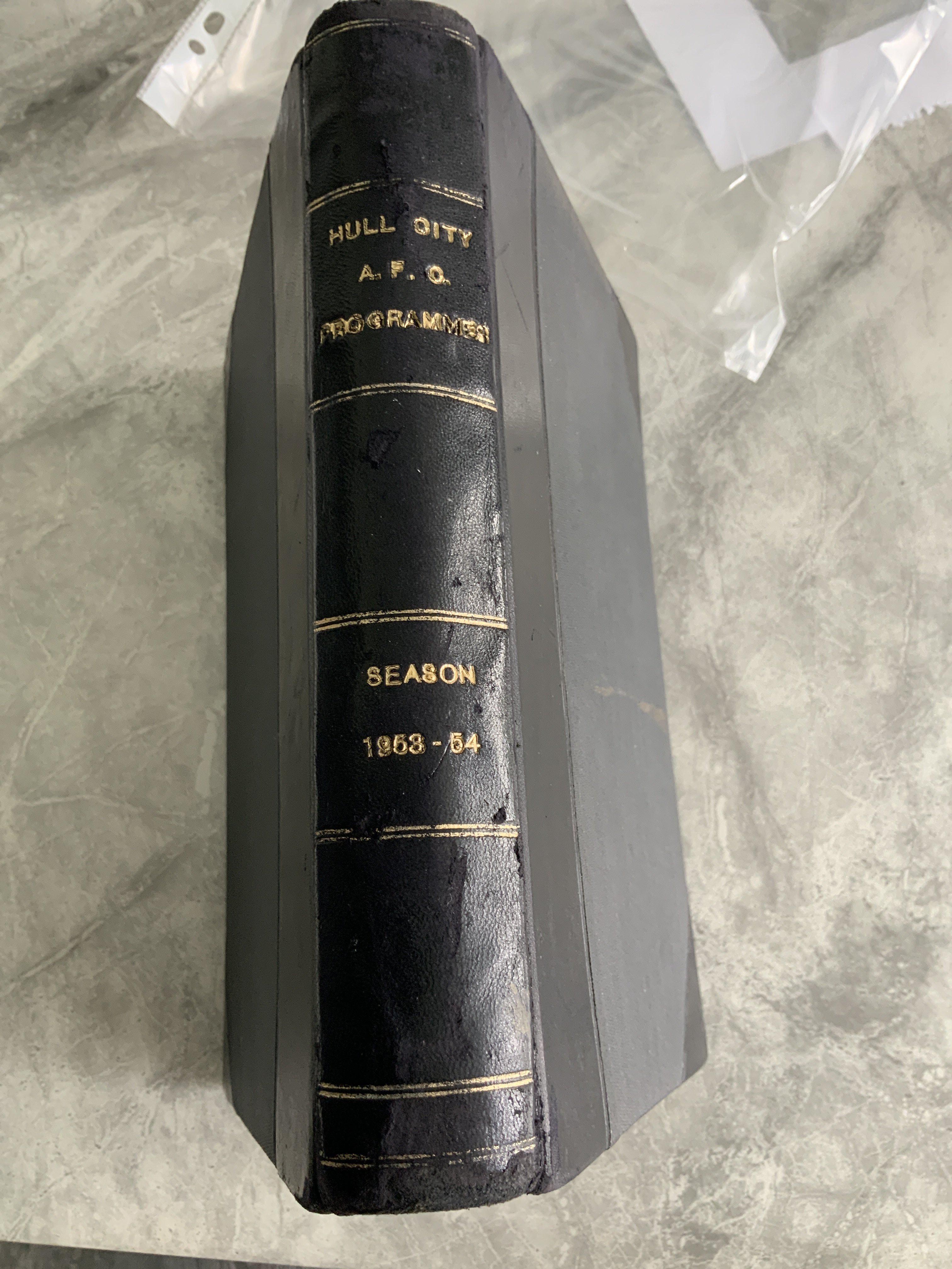 53/54 Hull City Bound Volume Of Football Programmes: Includes Arsenal, Grimsby East Riding Trophy, Falkirk, St Mirren, Admira Wien, FA Cup v Brentford, Tottenham + Blackburn. League matches complete and in stunning unwritten condition with covers. Blue boards state Hull City AFC Programmes Season 1953-54 to spine.
