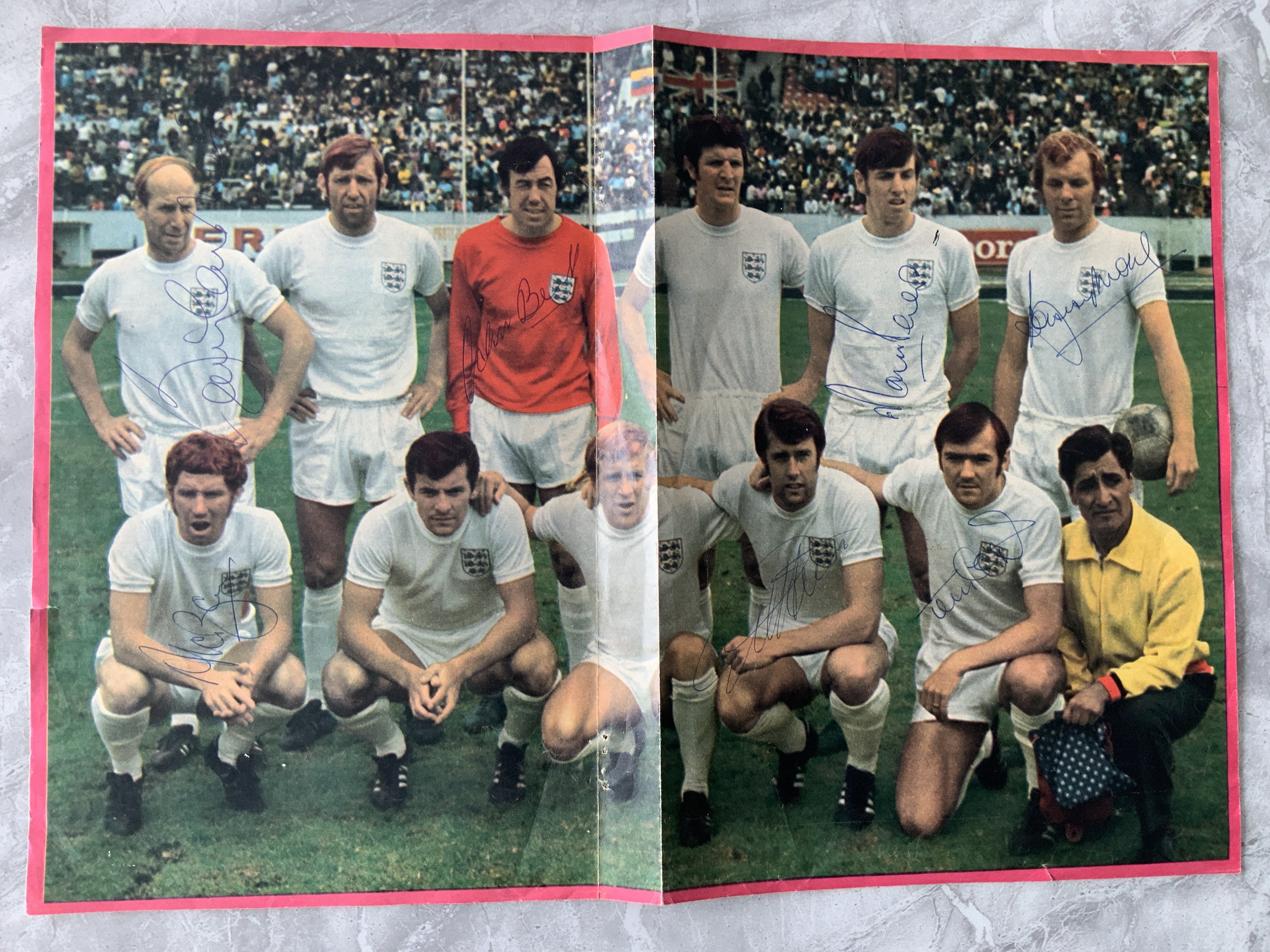 England 1970 World Cup Signed Football Team Group: Large double page colourful magazine picture of 11 players of which Moore Peters Hurst B Charlton Banks Ball and Cooper have all signed. C/W full size magazine picture of 5 England legends signed by Flowers Haynes McNeil and Swan.