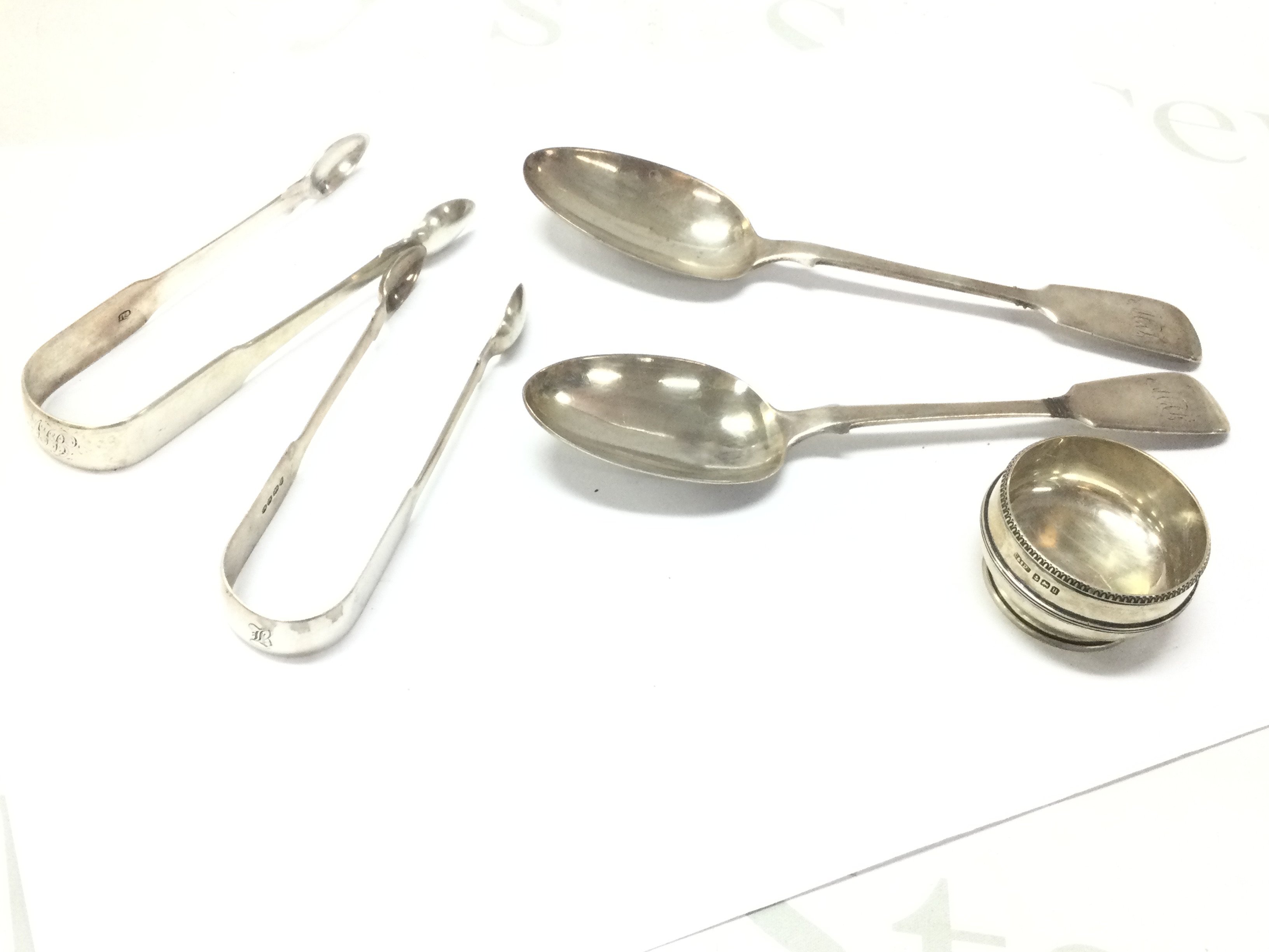 Silver hallmarked items- A pair of Georgian serving spoons, two sugar tongs and a salt bowl