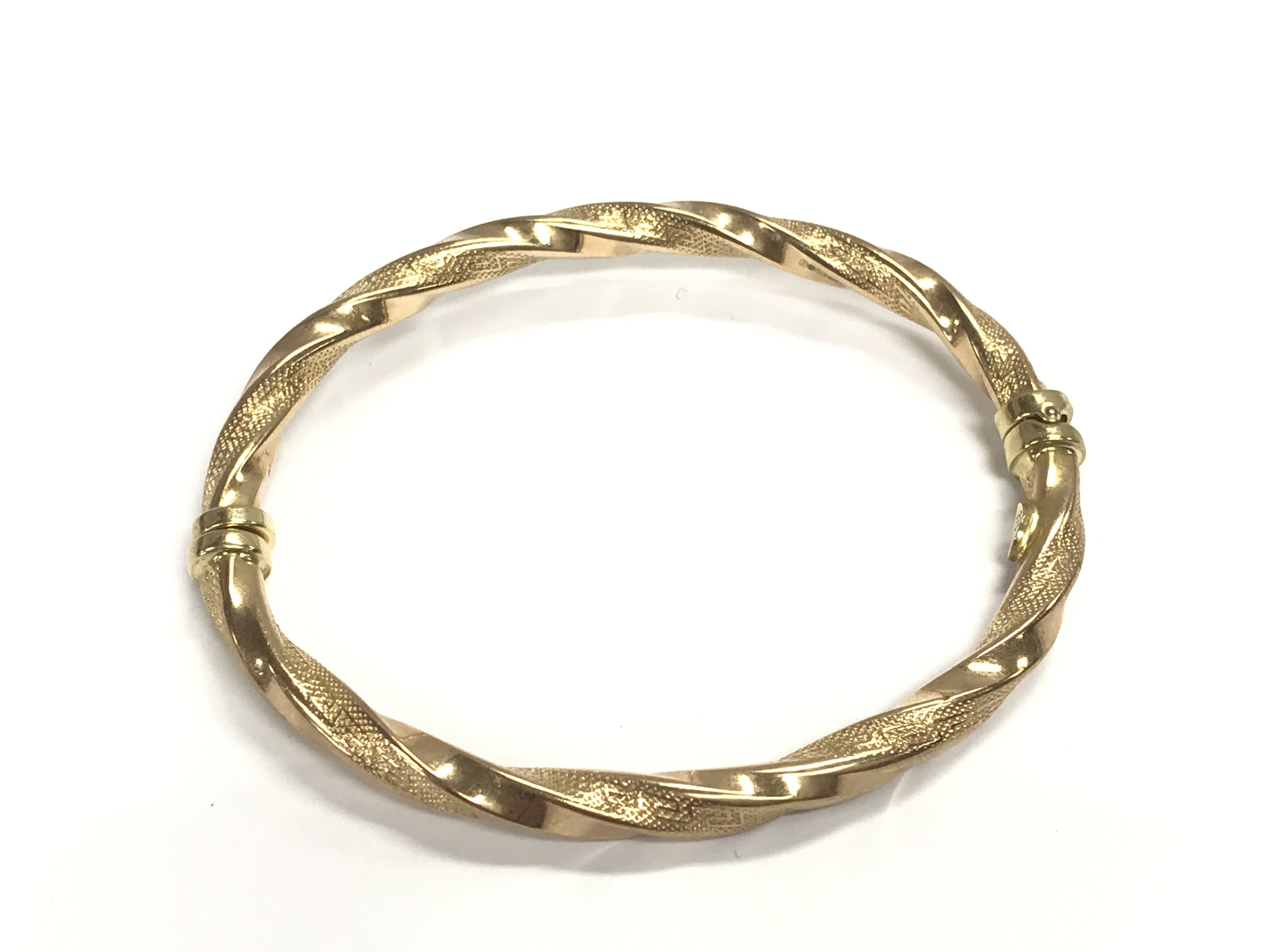 A 9ct gold bangle. 6.45g and approximately 7cm diameter.