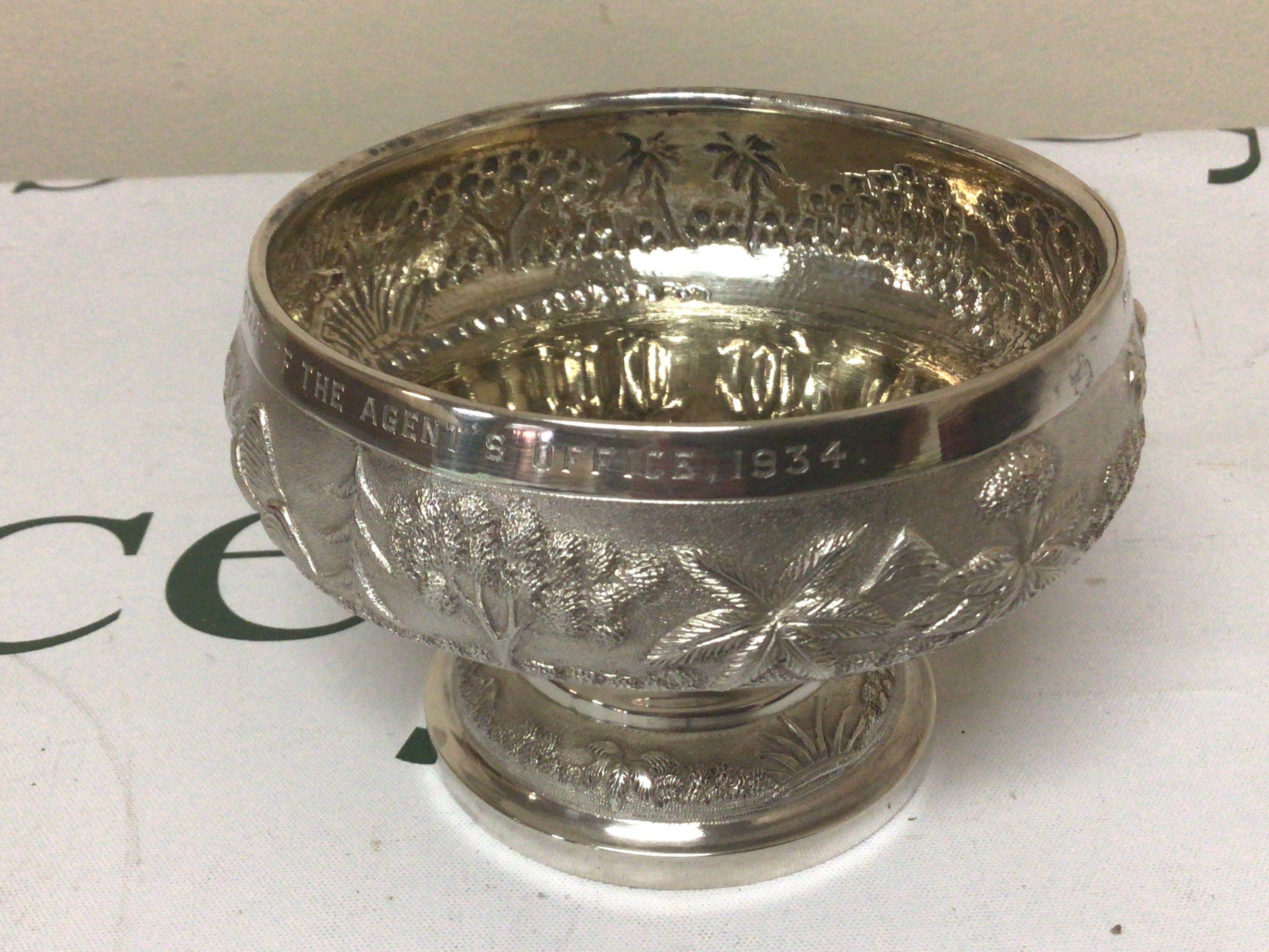 An Indian silver rose bowl with Repousse chased decoration the edge with an inscription and date 1934. Indian silver marks to the base. Weight 224g
