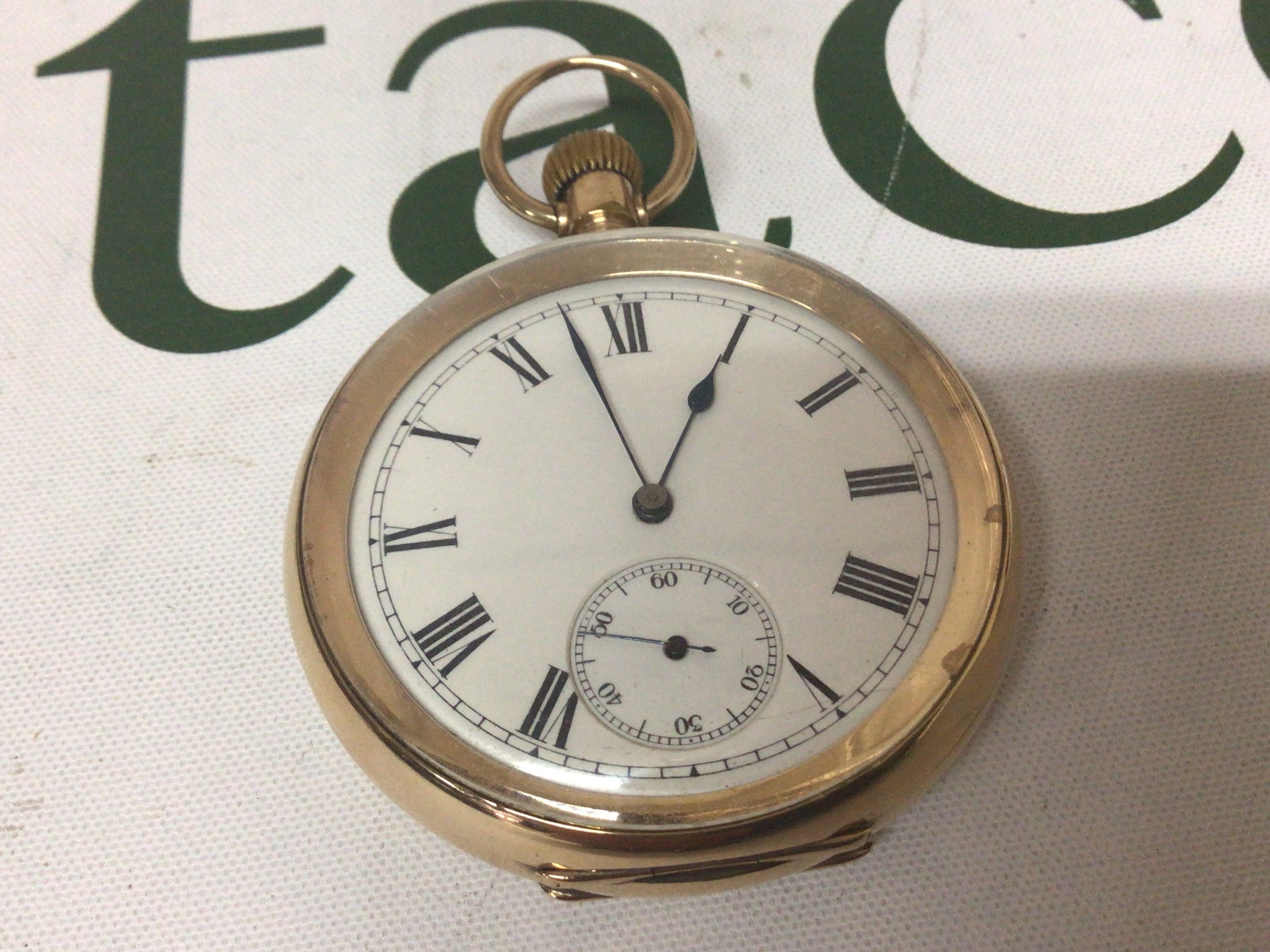 An Elgin gold plated button wind pocket watch with a white enamel dial the inner back plate with personal inscription dated 1913.