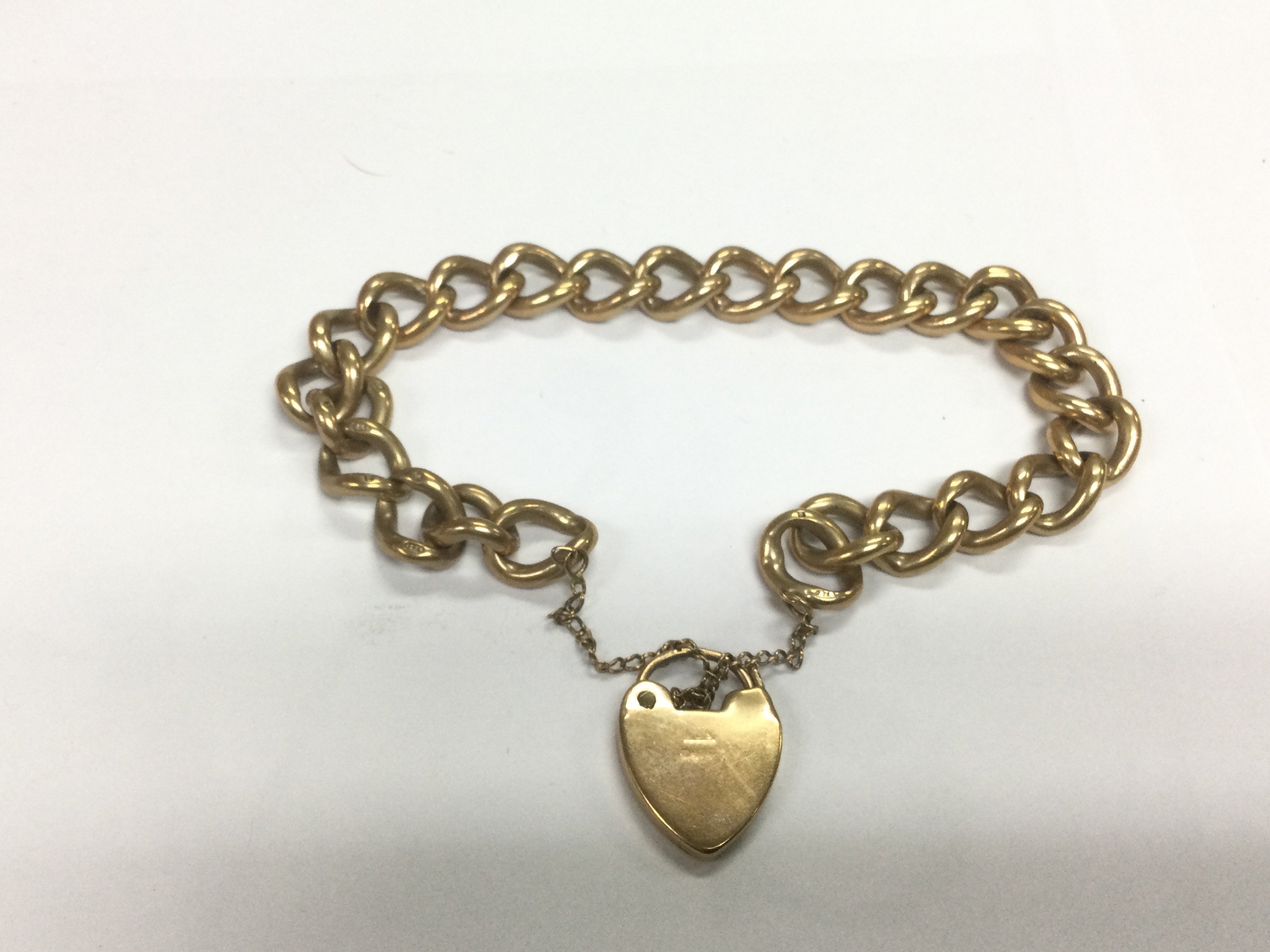 A 9ct gold open link bracelet with a 9ct gold heart shaped padlock pendant, approx weight 38.7. Shipping category A.