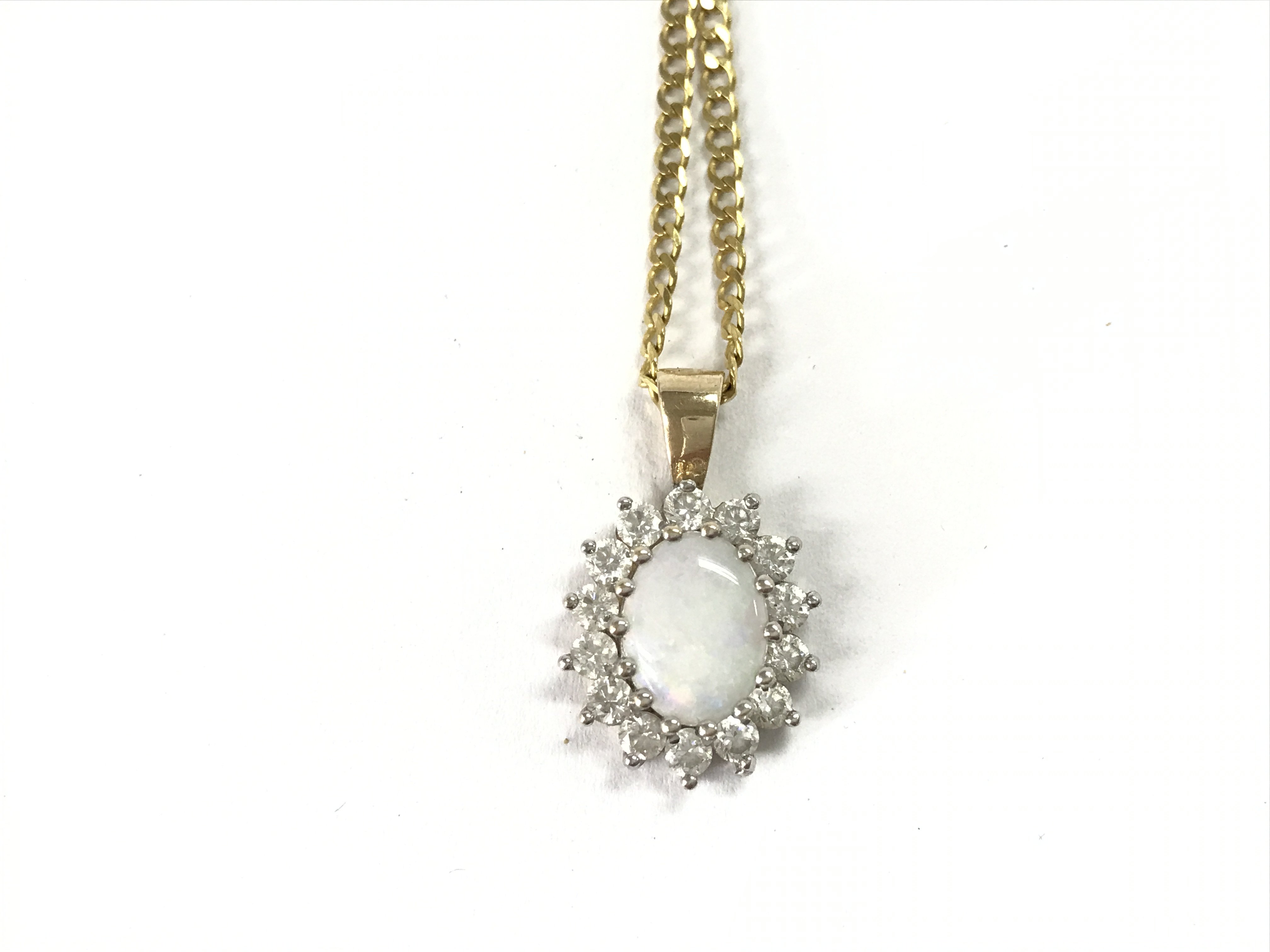 A 9ct gold chain with a 9ct Opal and white stone pendant. 5.09g total. Postage A