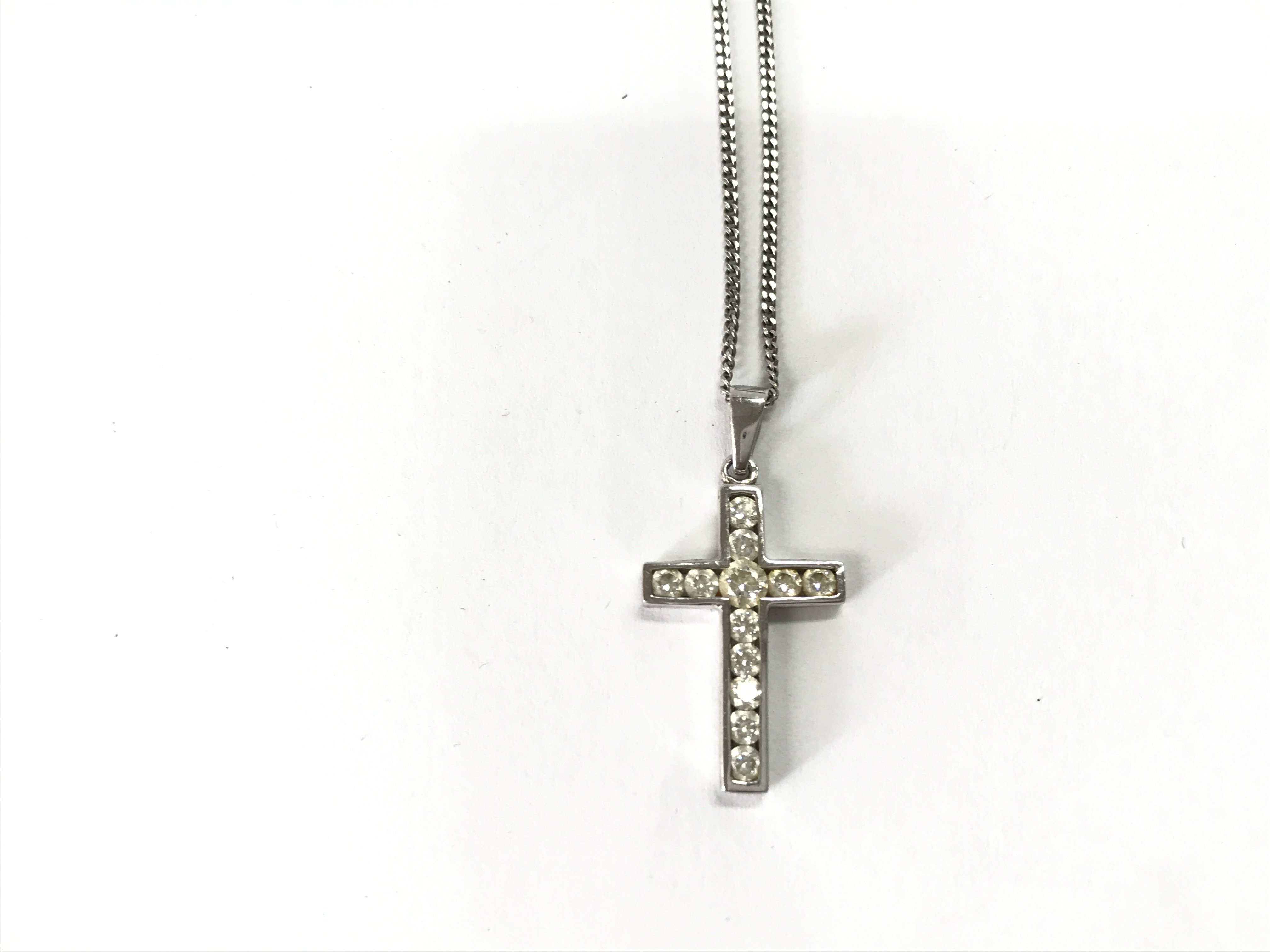 A 9ct white gold chain with a 9ct stone set cross pendant. 4g