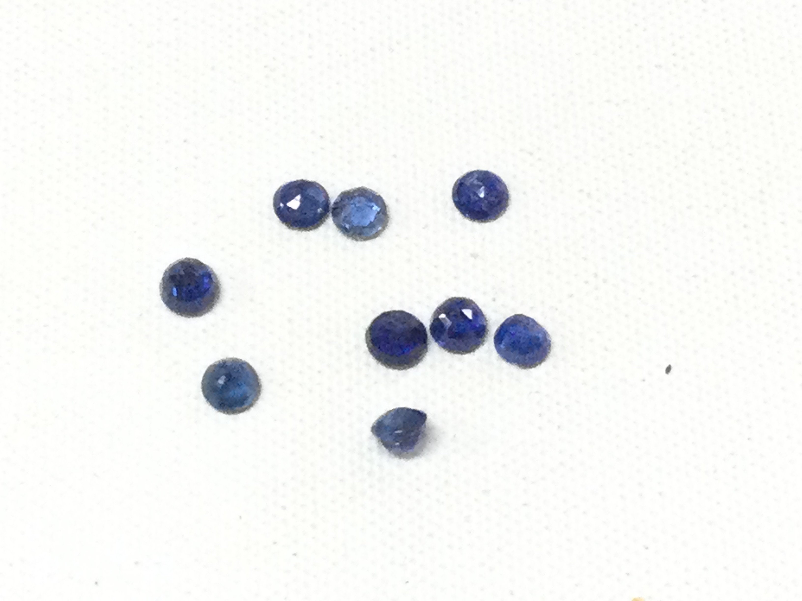 Parcel of 9 loose, unmounted round-cut blue and blue-green sapphires totalling 2.26ct