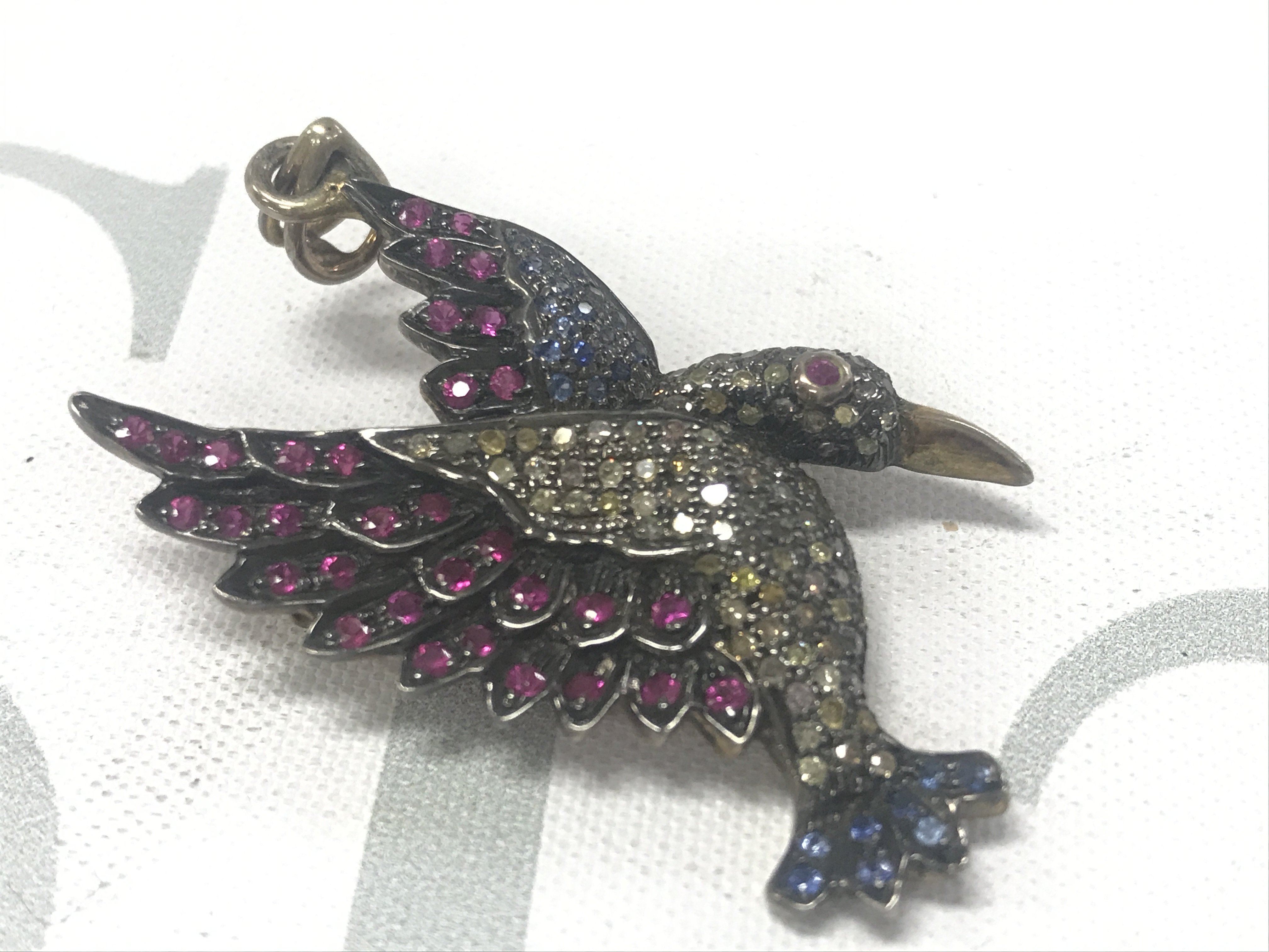 Silver gilt bird brooch/pendant set with rubies, sapphires and diamonds. Rubies 0.50ct approx.