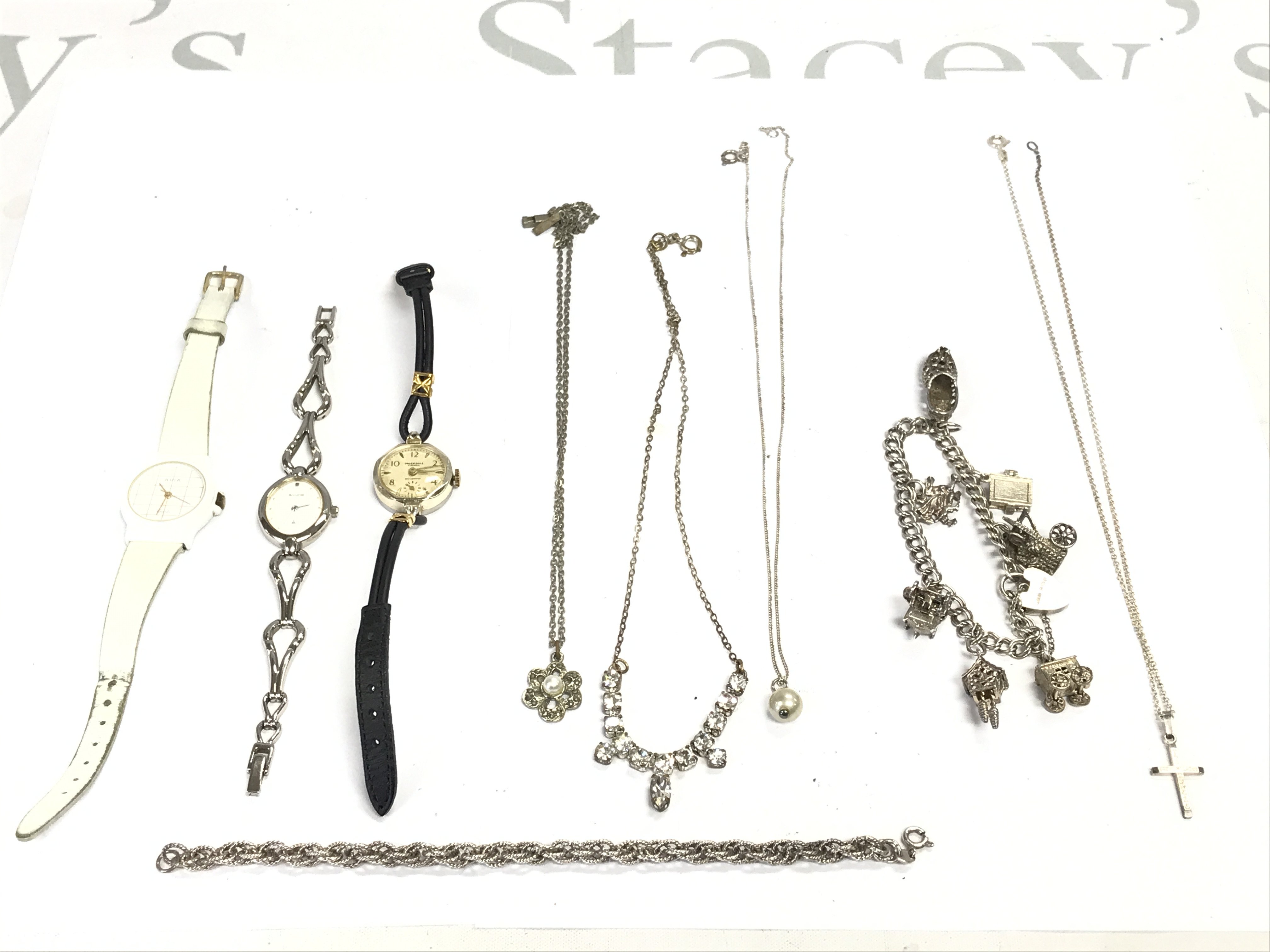 A collection of silver jewellery including a charm bracelet and some watches. Postage B