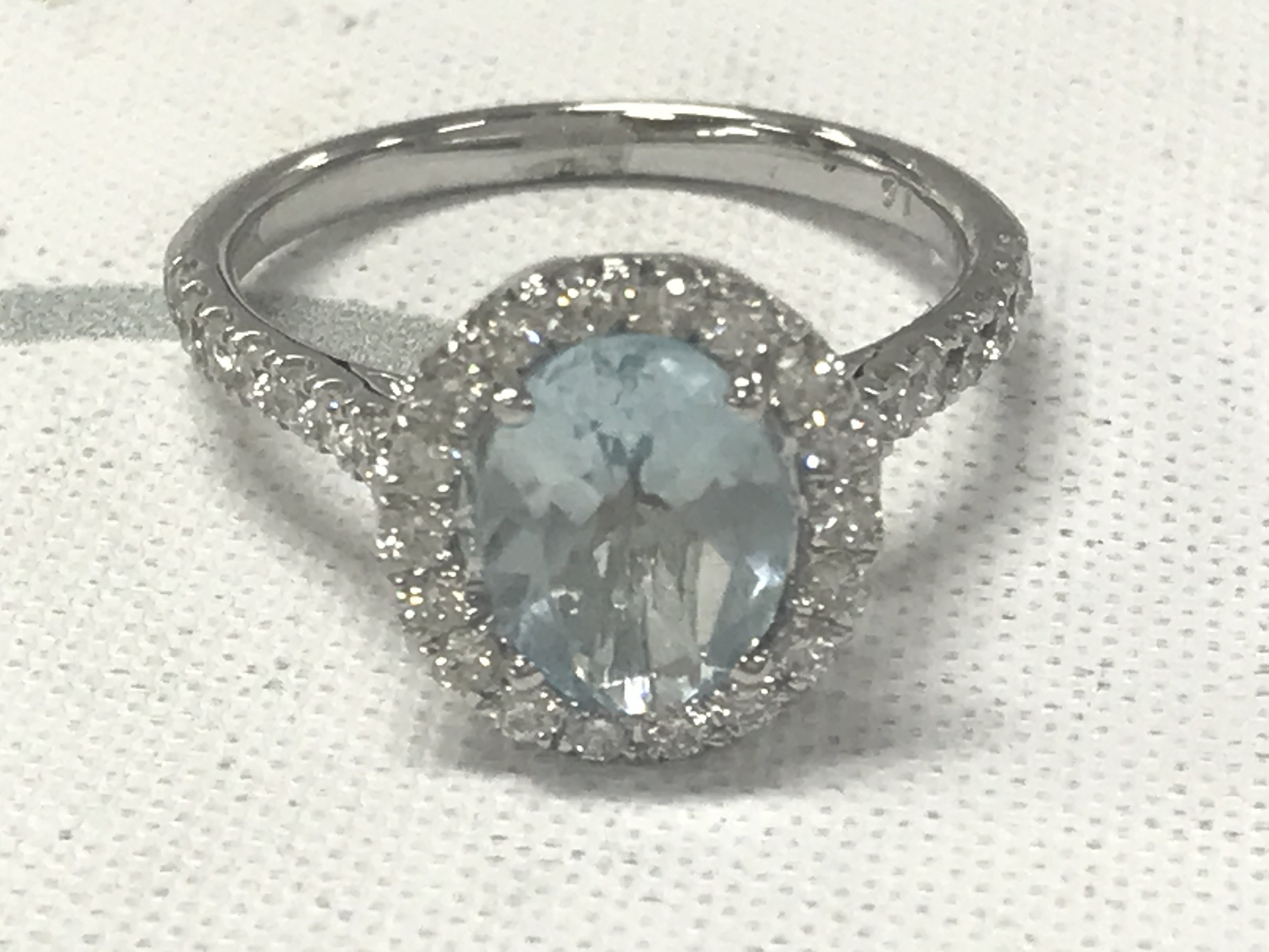 9ct white gold oval aquamarine and RBC diamond cluster ring with diamond set shoulders. Aquamarine 1.43ct. Diamonds 0.55ct.