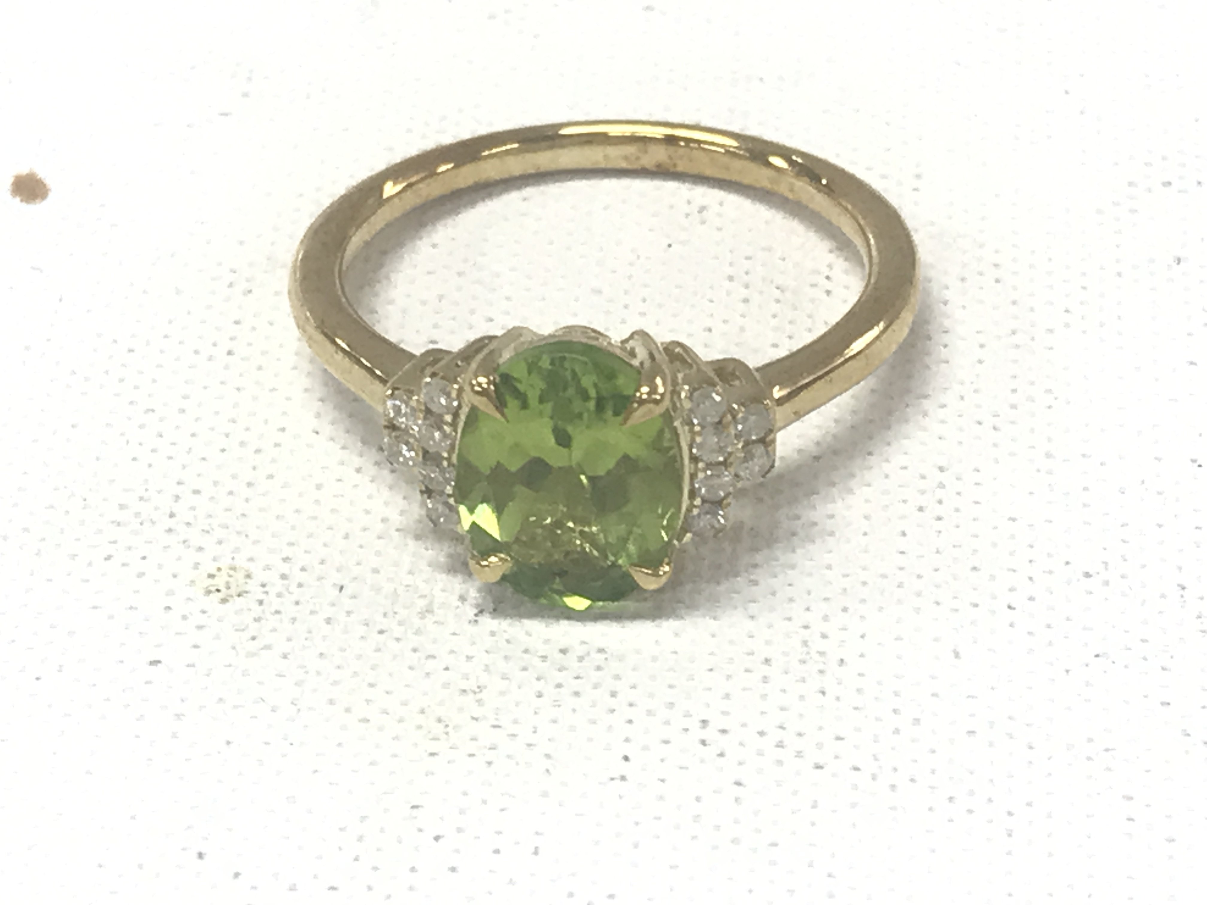 9ct yellow gold oval peridot ring with RBC diamond tiered shoulders. Peridot 2.25ct. Diamonds 0.11ct.