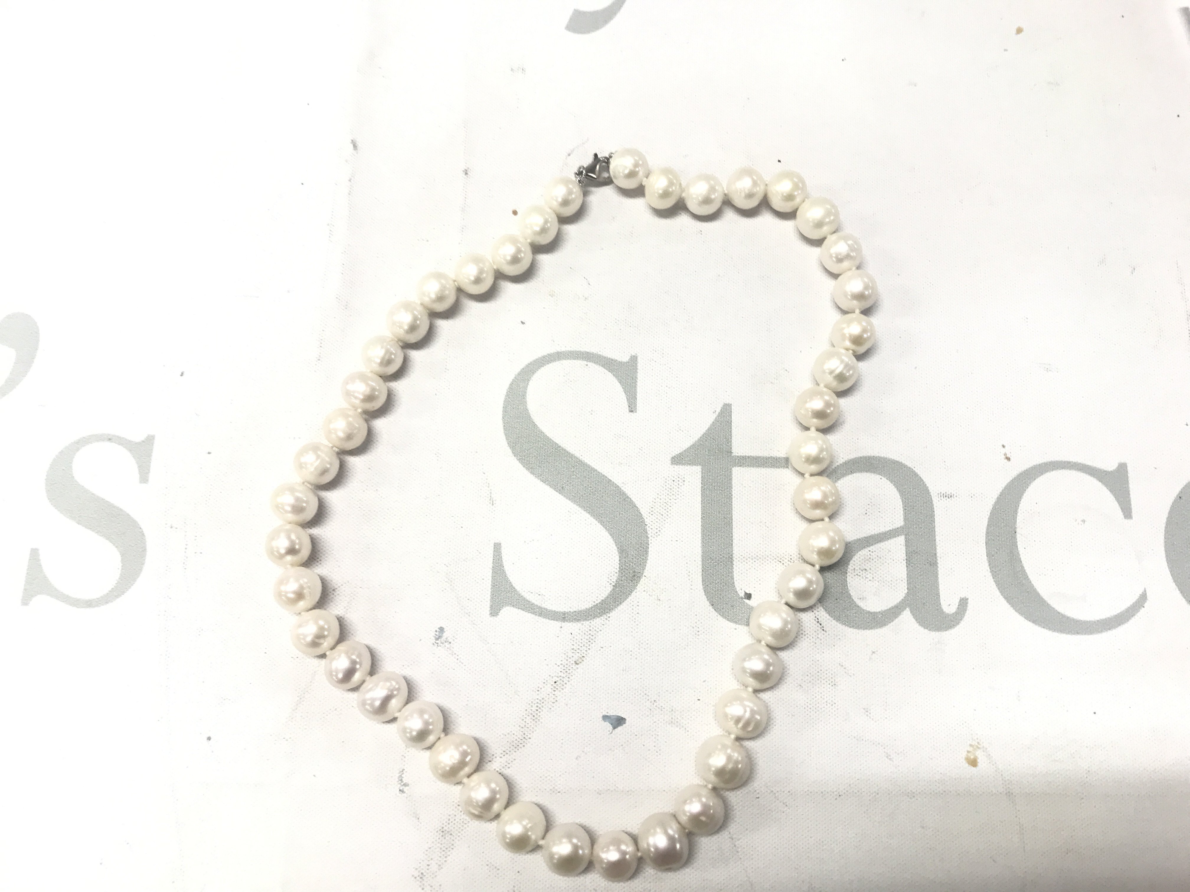 18" white cluttered pearl necklace with a silver lobster claw clasp.