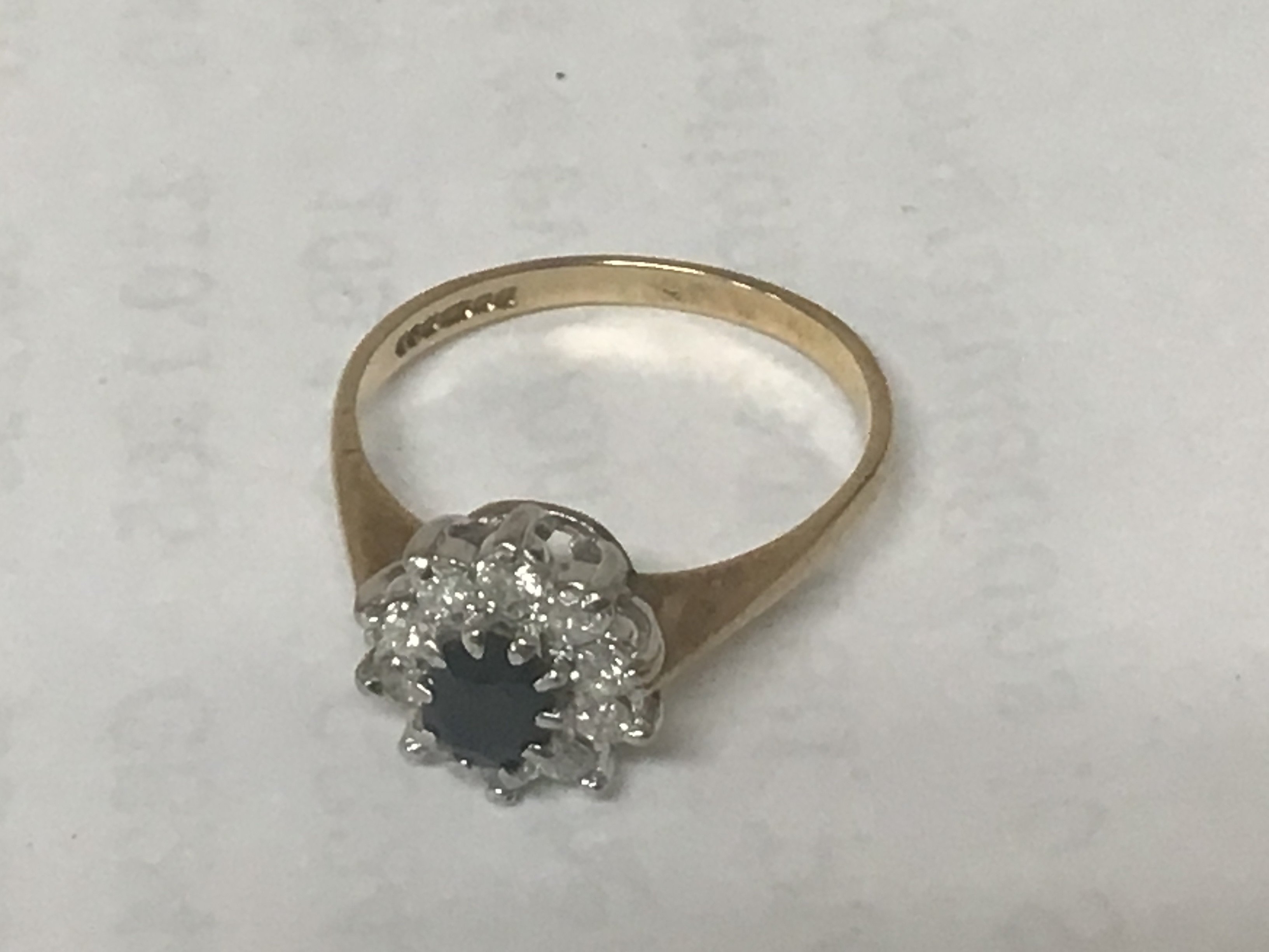 A 9 carat gold ring set with blue sapphire and diamonds. Weight 2g