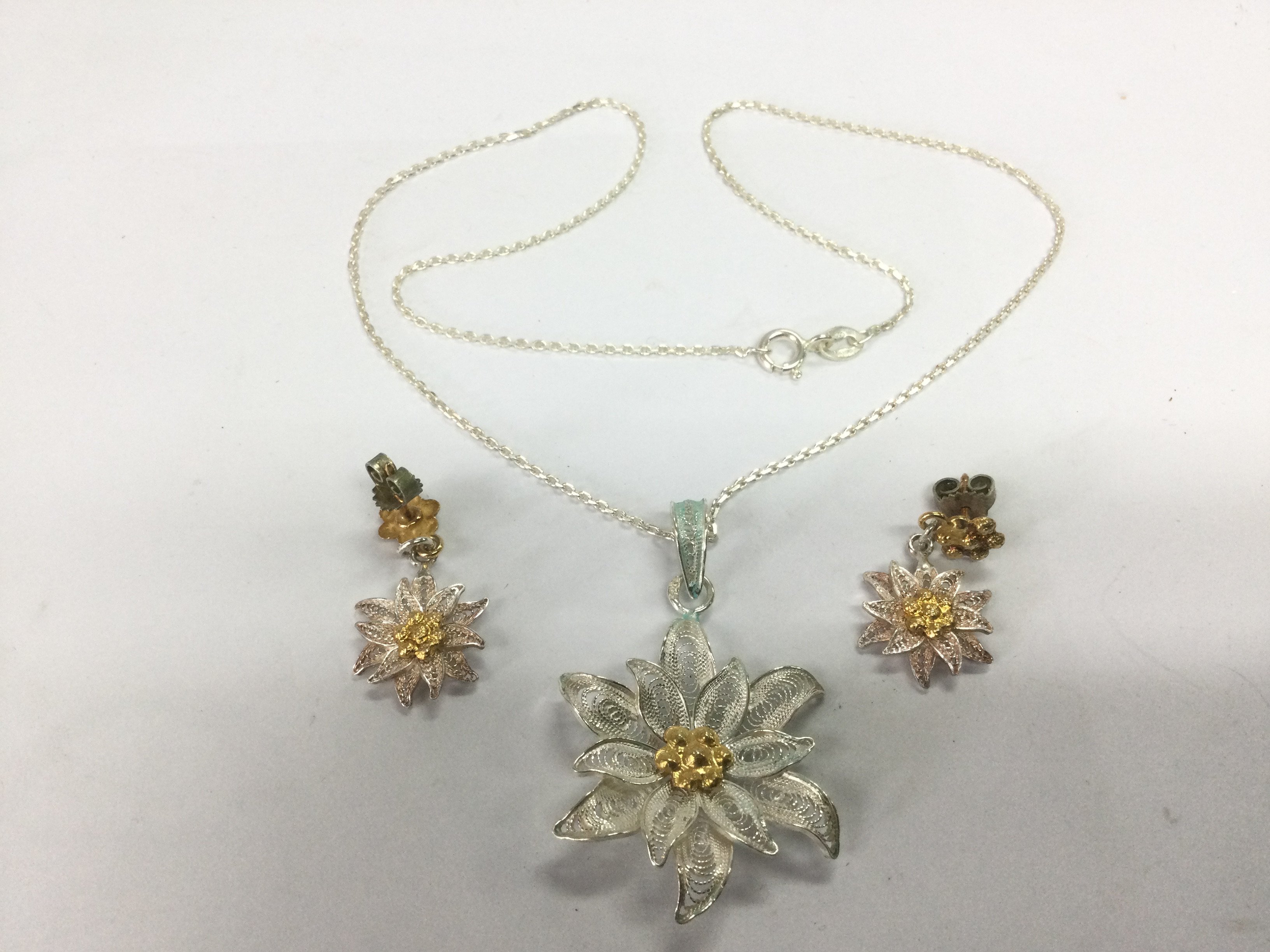 A silver filigree pendant and matching pair of earrings. Shipping category A.