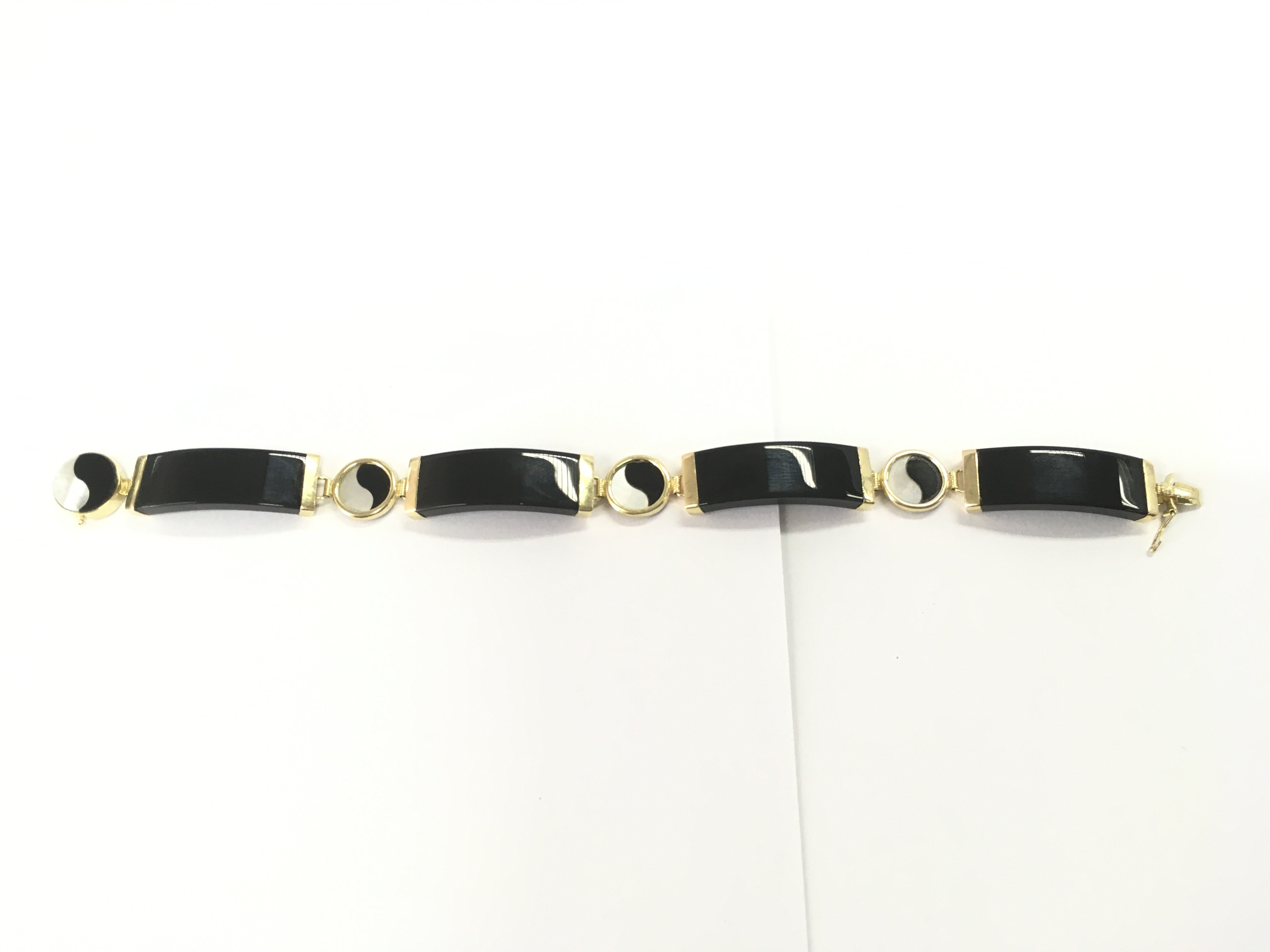 A 14ct gold and black phenolic bracelet. 19cm length and 16.52g