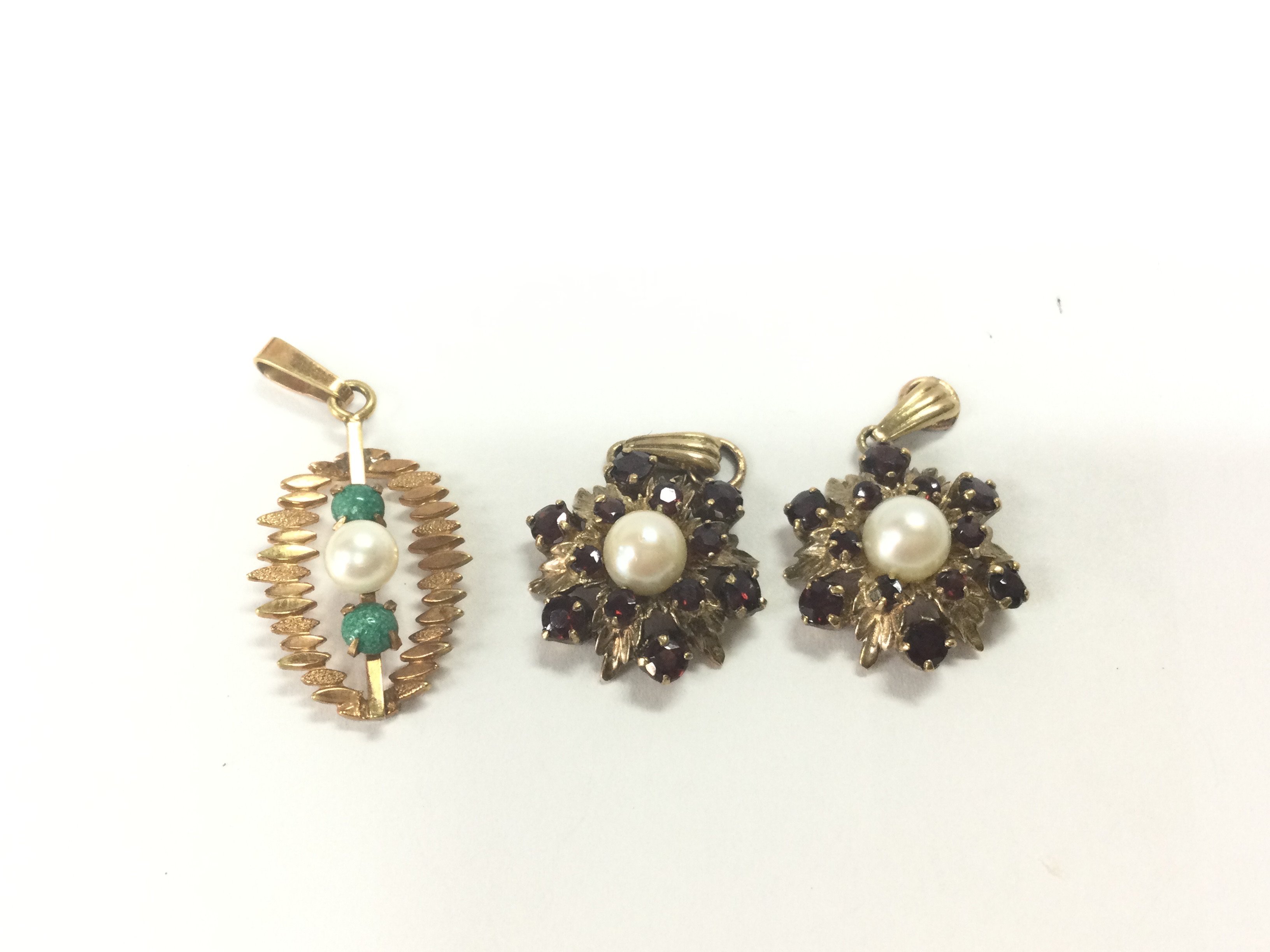 Three 9ct gold pendants set with pearls and other stones. 7.33g Postage A